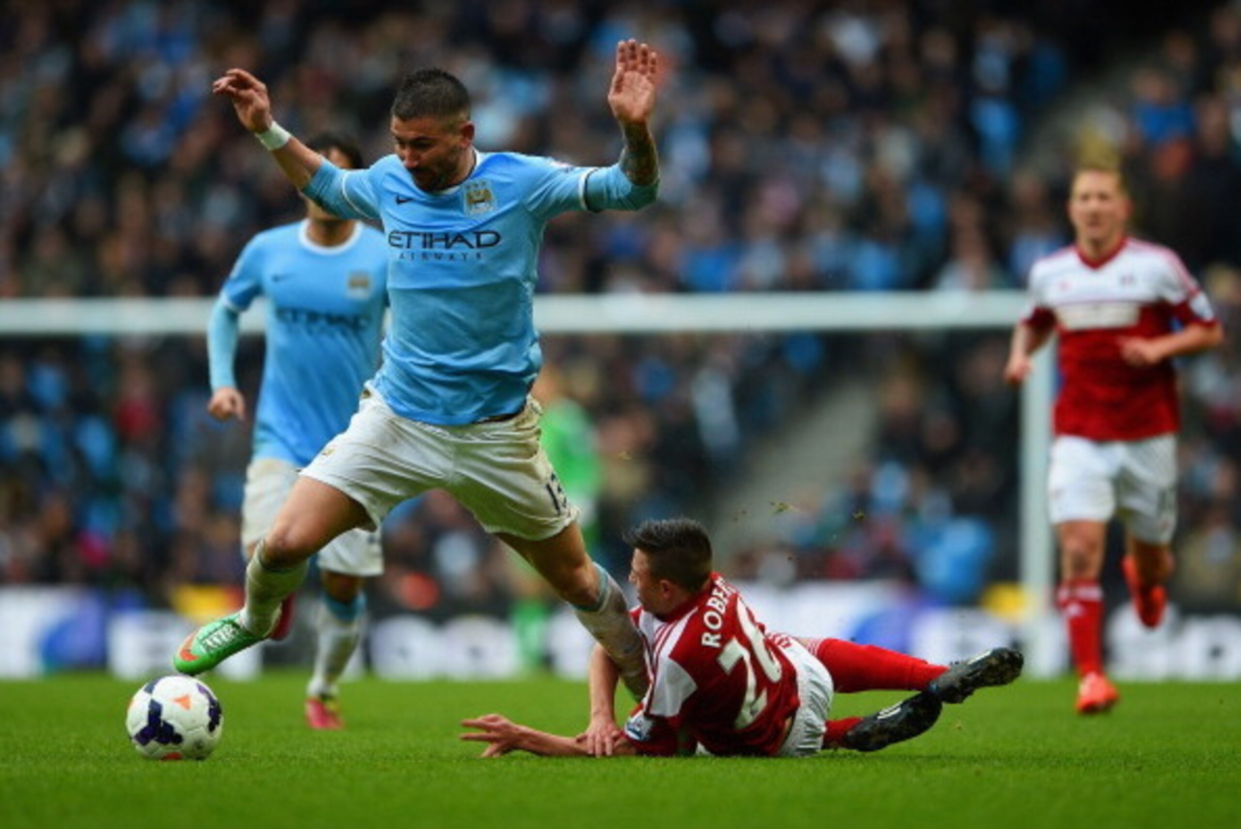 MANCHESTER, ENGLAND - MARCH 22:  Aleksandar Kolarov of Manchester City clashes with Patrick Roberts of Fulham  during the Barclays Premier League match between Manchester City and Fulham at Etihad Stadium on March 22, 2014 in Manchester, England.  (Photo 