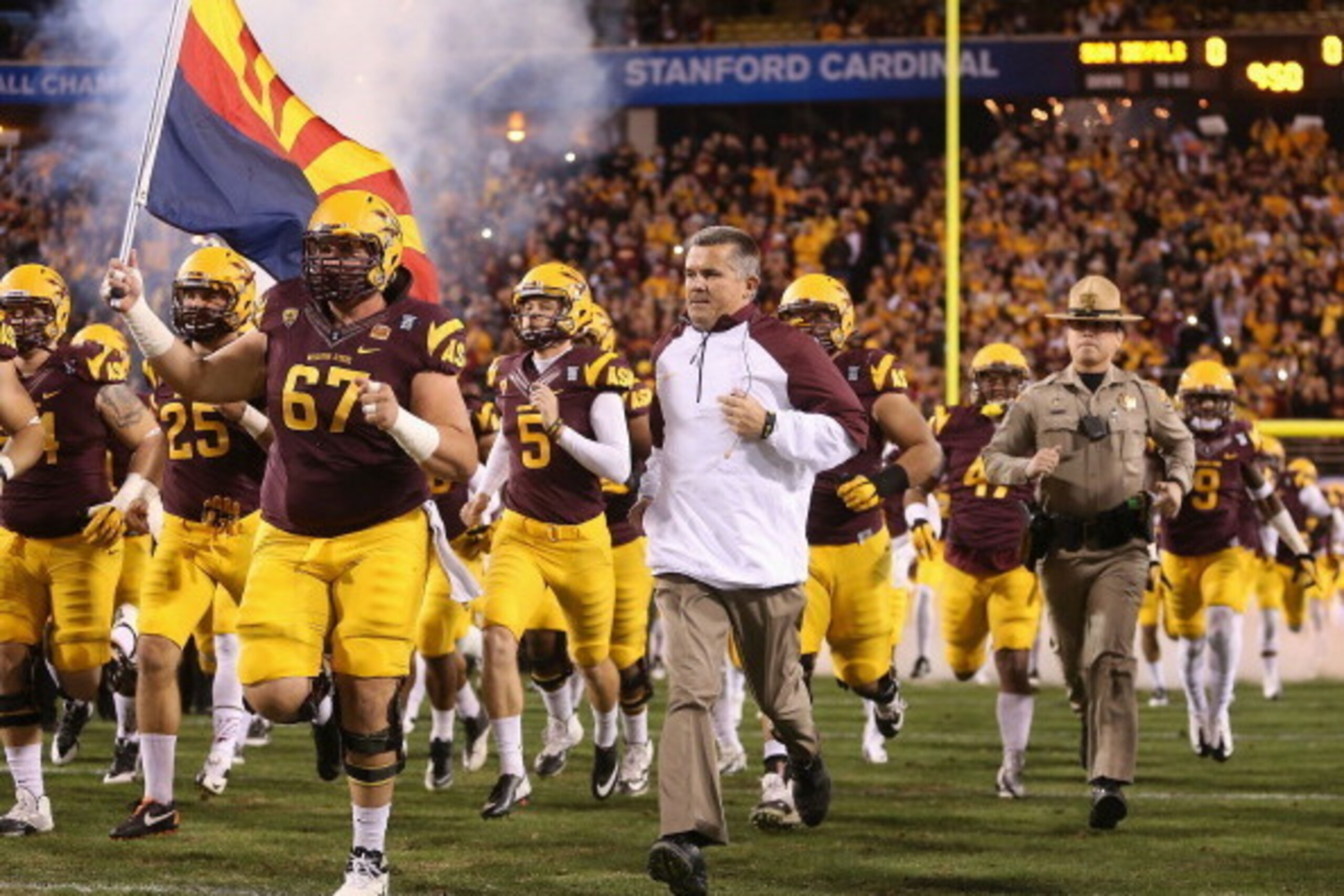 TEMPE, AZ - DECEMBER 07:  Head coach Todd Graham of the Arizona State Sun Devils runs out with teammates before the Pac 12 Championship game against the Stanford Cardinal at Sun Devil Stadium on December 7, 2013 in Tempe, Arizona. The Carindal defeated th
