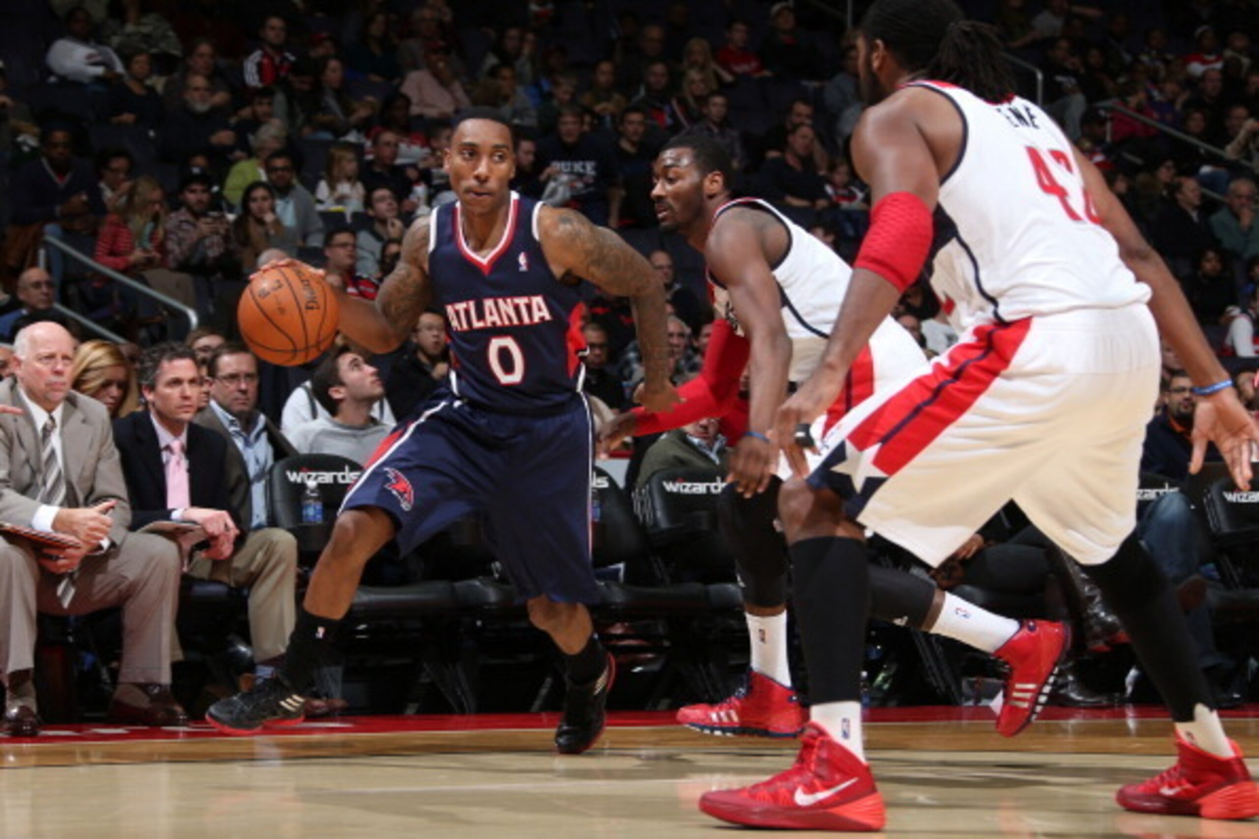 WASHINGTON, DC - NOVEMBER 30: Jeff Teague #0 of the Atlanta Hawks drives against John Wall #2 and Nene #42 of the Washington Wizards during the game at the Verizon Center on November 30, 2013 in Washington, DC. NOTE TO USER: User expressly acknowledges an