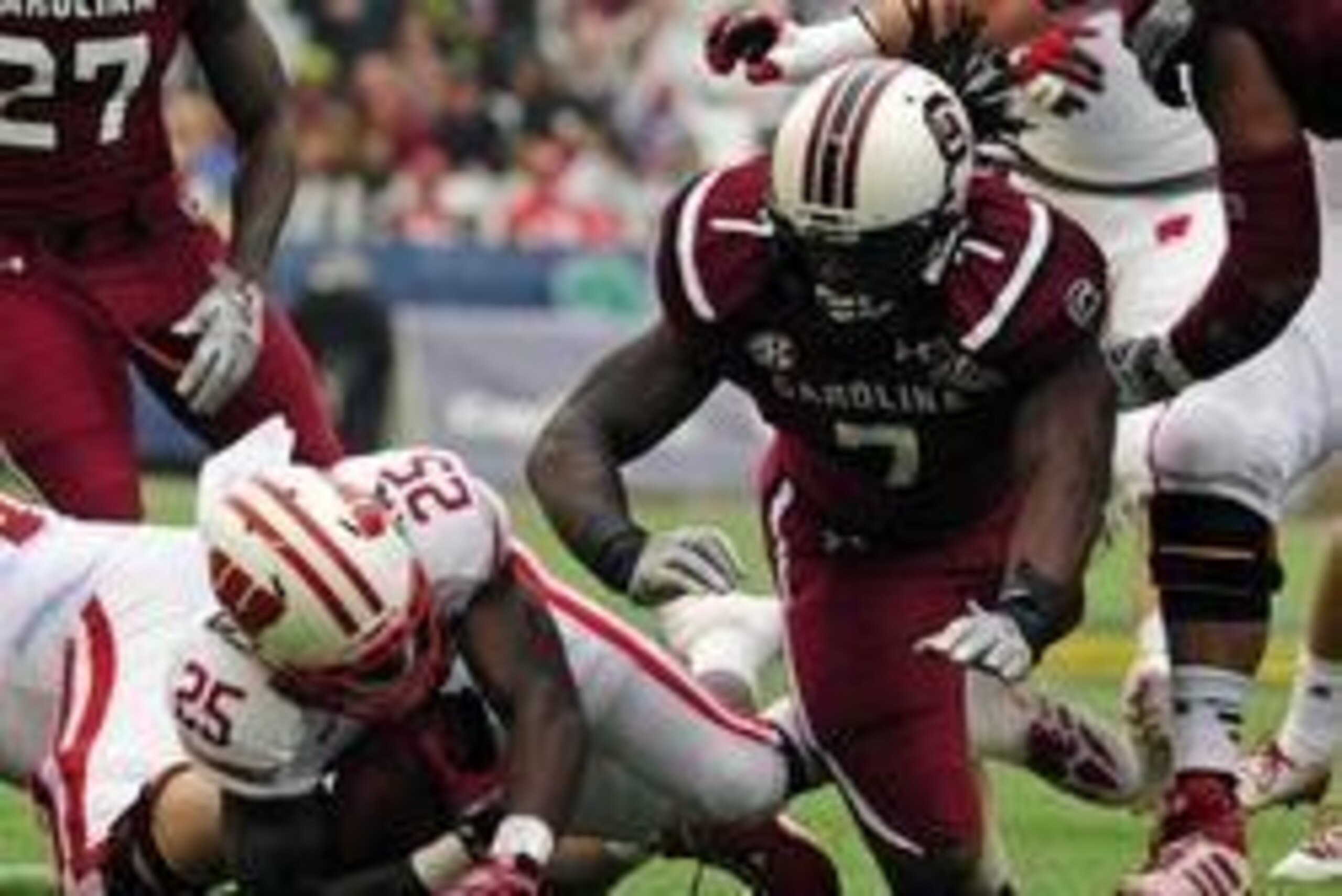 Jan 1, 2014; Orlando, FL, USA; South Carolina Gamecocks defensive end Jadeveon Clowney (7) knocks down Wisconsin Badgers running back Melvin Gordon (25) in the first quarter as the South Carolina Gamecocks face the Wisconsin Badgers in the Capital One Bow