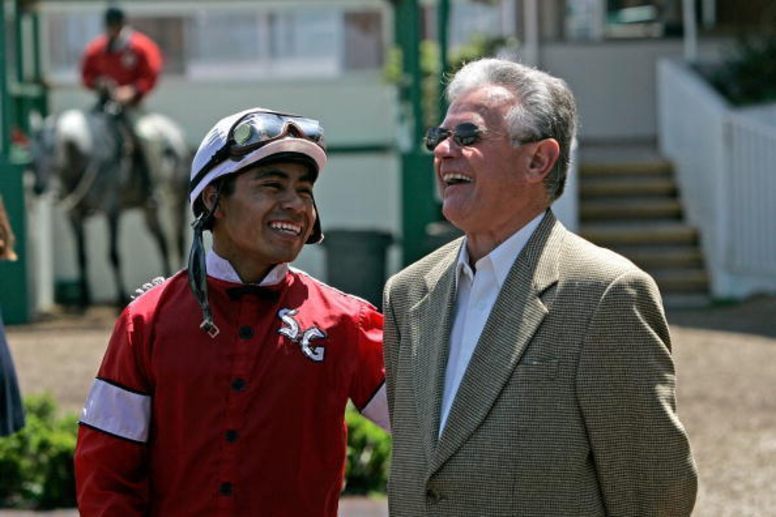 ALBANY, CA - APRIL 28:  Apprentice Jockey Martin Garcia (L) of Mexico laughs with horse trainer Art Sherman before the start of the third race at Golden Gate Fields April 28, 2006 in Albany, California. Garcia, 21, came to the United States from Veracruz,