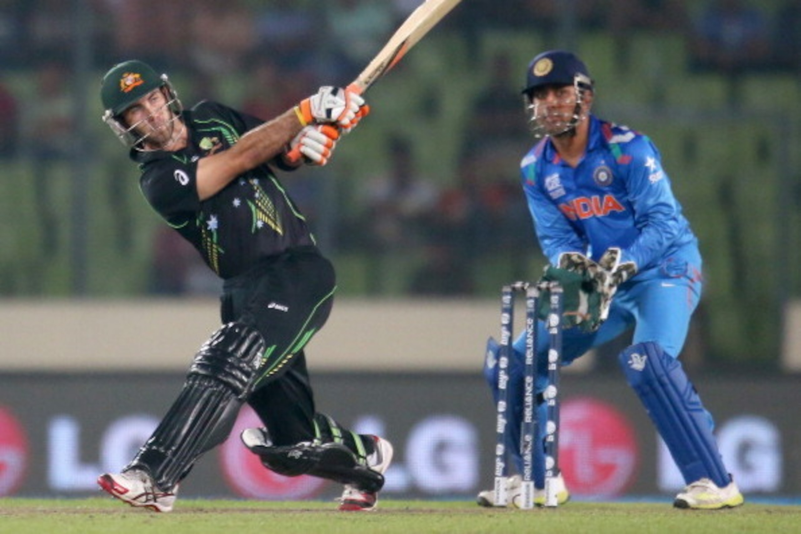 DHAKA, BANGLADESH - MARCH 30: Glenn Maxwell of Australia hits a six as MS Dhoni of India looks on during the ICC World Twenty20 Bangladesh 2014 match between India v Australia at Sher-e-Bangla Mirpur Stadium on March 30, 2014 in Dhaka, Bangladesh. (Phot DHAKA, BANGLADESH - MARCH 30: Glenn Maxwell of Australia hits a six as MS Dhoni of India looks on during the ICC World Twenty20 Bangladesh 2014 match between India v Australia at Sher-e-Bangla Mirpur Stadium on March 30, 2014 in Dhaka, Bangladesh. (Phot