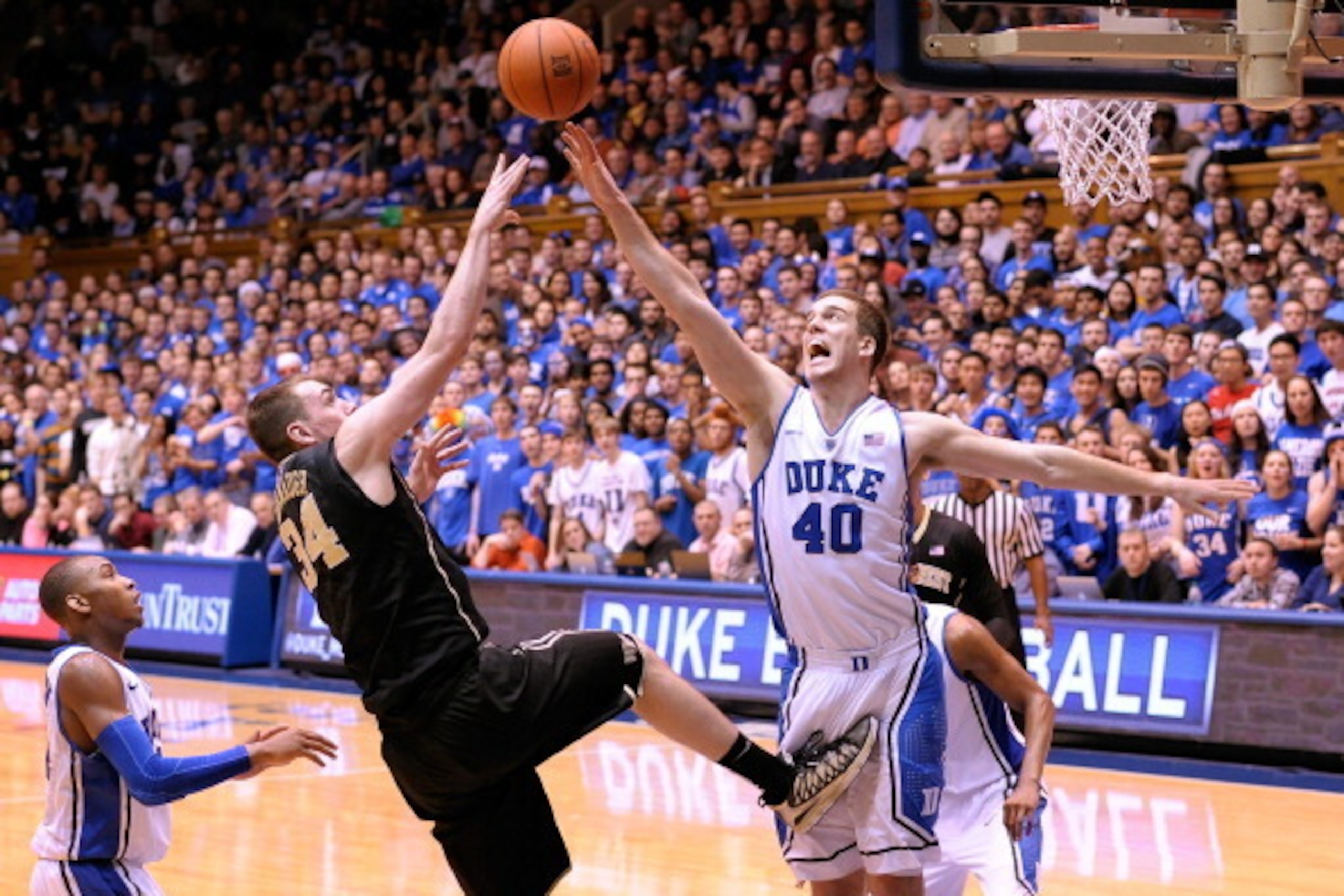 DURHAM, NC - FEBRUARY 04:  Tyler Cavanaugh #34 of the Wake Forest Demon Deacons shoots over Marshall Plumlee #40 of the Duke Blue Devils during their game at Cameron Indoor Stadium on February 4, 2014 in Durham, North Carolina. Duke won 83-63.  (Photo by 