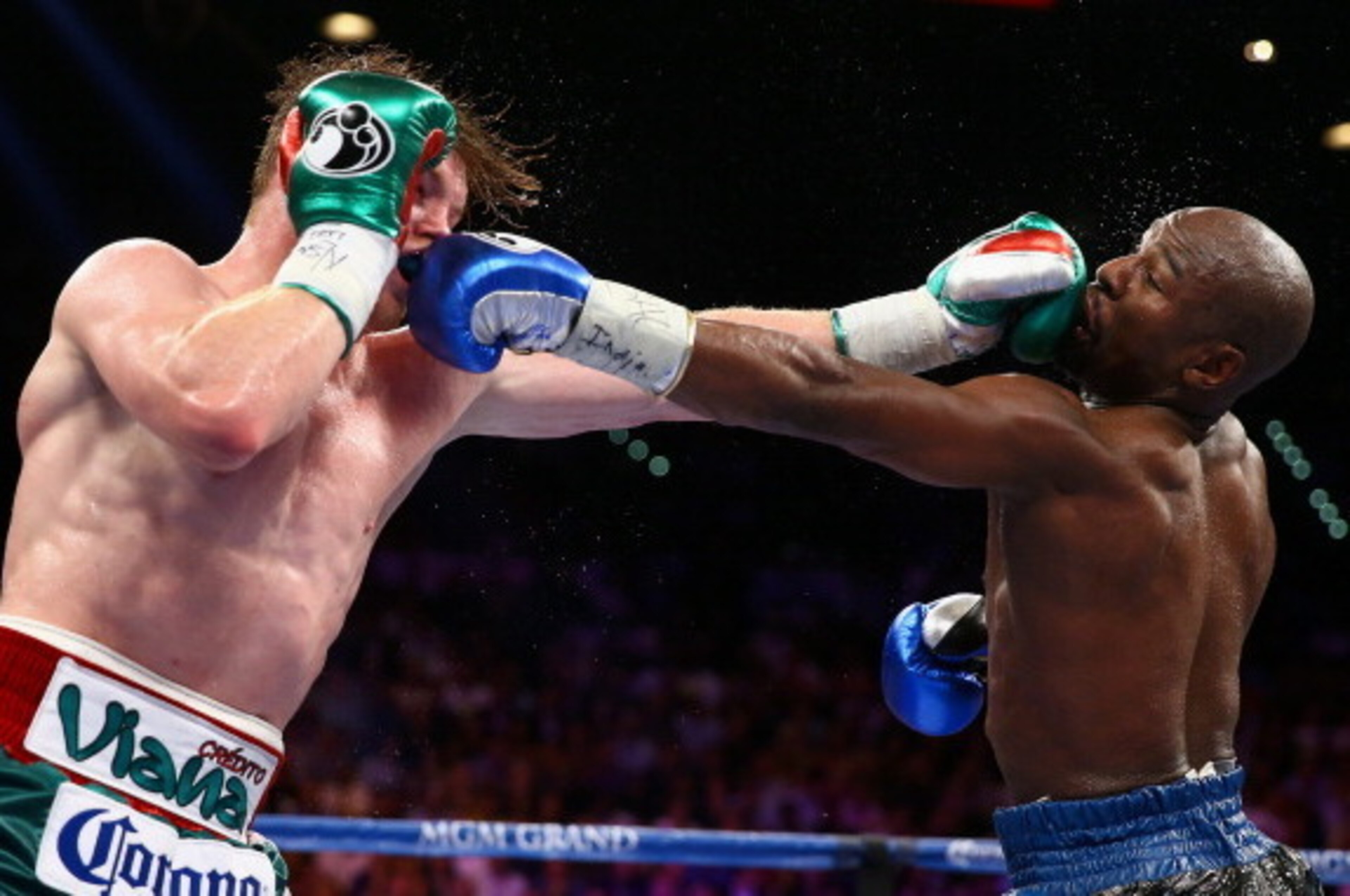 LAS VEGAS, NV - SEPTEMBER 14:  (L-R) Floyd Mayweather Jr. and Canelo Alvarez exchange punches during their WBC/WBA 154-pound title fight at the MGM Grand Garden Arena on September 14, 2013 in Las Vegas, Nevada.  (Photo by Al Bello/Getty Images)