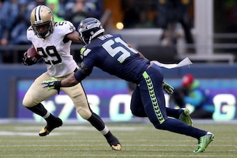 SEATTLE, WA - JANUARY 11:  Running back Khiry Robinson #29 of the New Orleans Saints runs the ball against outside linebacker Bruce Irvin #51 of the Seattle Seahawks in the first half during the NFC Divisional Playoff Game at CenturyLink Field on January 