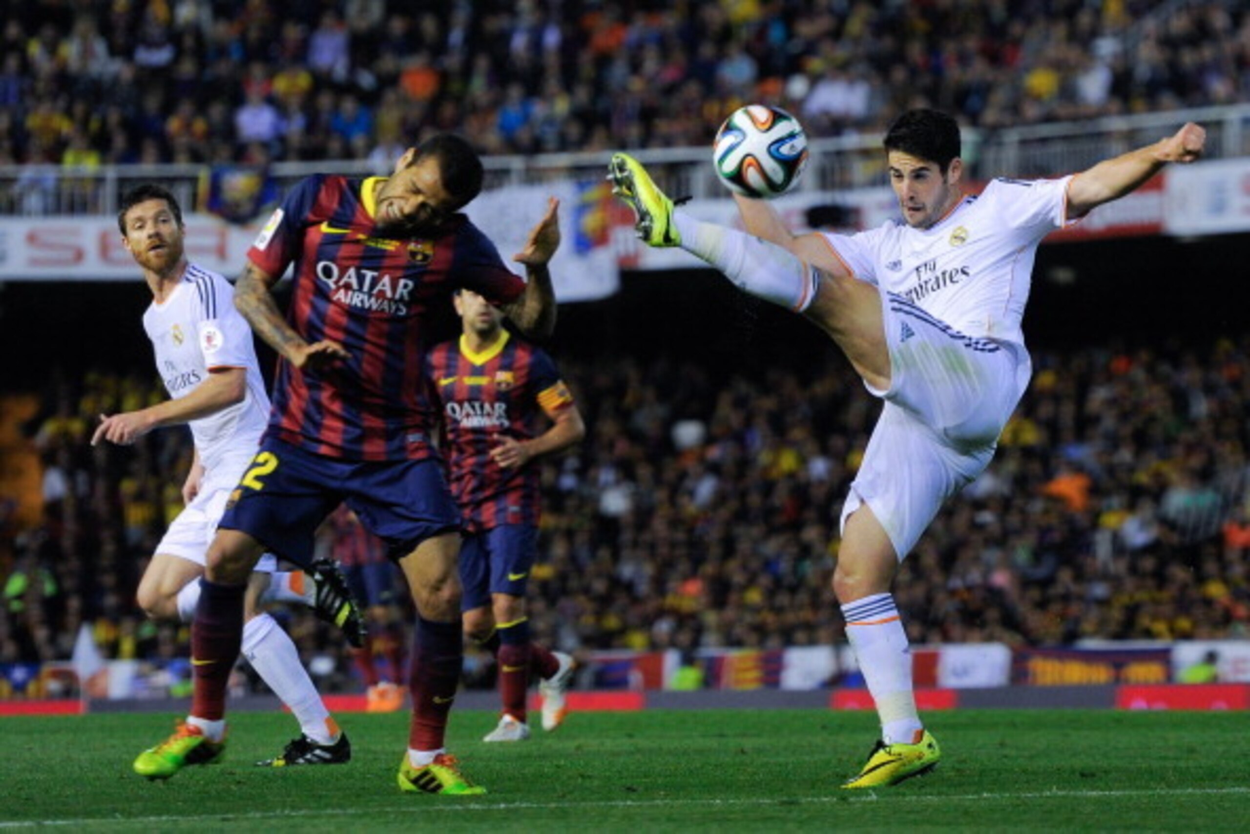 VALENCIA, SPAIN - APRIL 16:  Francisco Alarcon Isco of Real Madrid CF clears the ball under pressure from Dani Alves of FC Barcelona during the Copa del Rey Final between Real Madrid and FC Barcelona at Estadio Mestalla on April 16, 2014 in Valencia, Spai