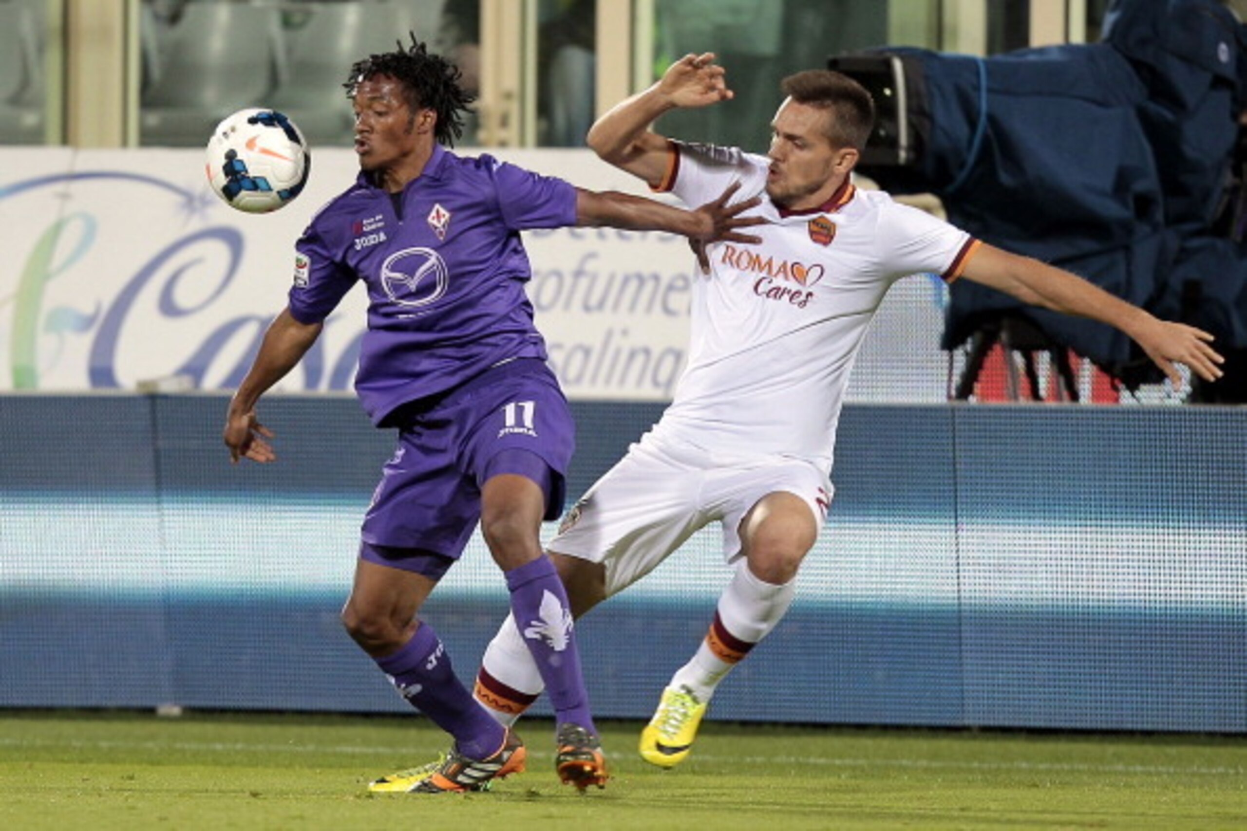 FLORENCE, ITALY - APRIL 19: Guillermo Cuadrado of ACF Fiorentina fights for the ball with Rafael Toloi of AS Roma during the Serie A match between ACF Fiorentina and AS Roma at Stadio Artemio Franchi on April 19, 2014 in Florence, Italy.  (Photo by Gabrie