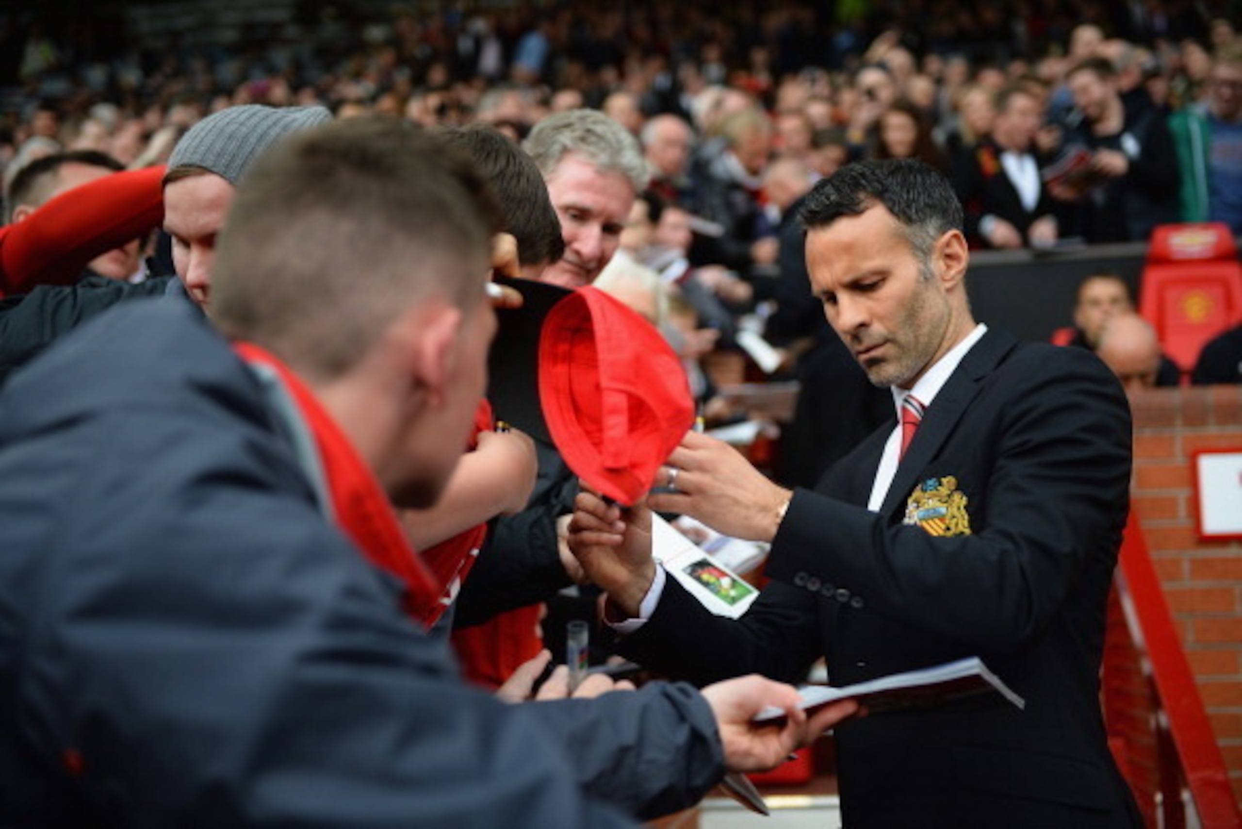 MANCHESTER, ENGLAND - APRIL 26:  Ryan Giggs of Manchester United signs autographs during the Barclays Premier League match between Manchester United and Norwich City at Old Trafford on April 26, 2014 in Manchester, England.  (Photo by Laurence Griffiths/G