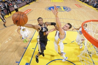 OAKLAND, CA - APRIL 6: Derrick Favors #15 of the Utah Jazz drives to the basket against the Golden State Warriors on April 6, 2014 at Oracle Arena in Oakland, California. NOTE TO USER: User expressly acknowledges and agrees that, by downloading and or usi