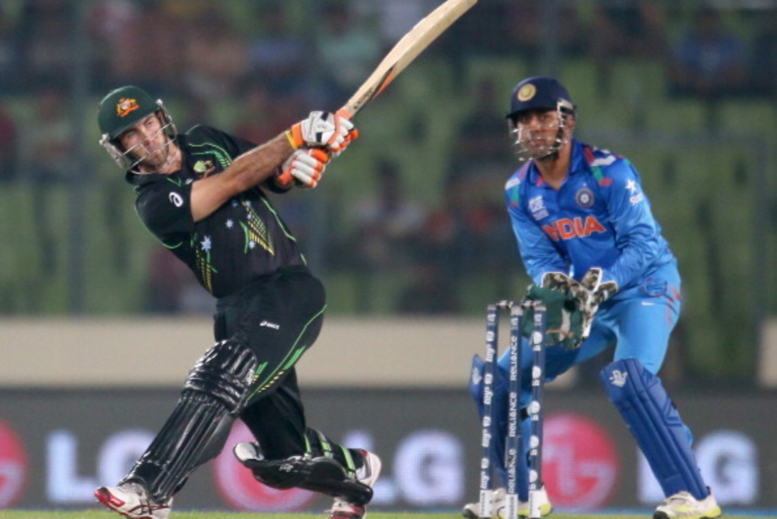 DHAKA, BANGLADESH - MARCH 30:  Glenn Maxwell of Australia hits a six as MS Dhoni of India looks on during the ICC World Twenty20 Bangladesh 2014 match between India v Australia at Sher-e-Bangla Mirpur Stadium on March 30, 2014 in Dhaka, Bangladesh.  (Phot