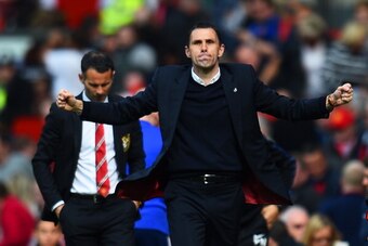 MANCHESTER, ENGLAND - MAY 03:  Gustavo Poyet the Sunderland manager celebrates his team's 1-0 victory as a dejected Ryan Giggs the Manchester United interim manager walks behind during the Barclays Premier League match between Manchester United and Sunder