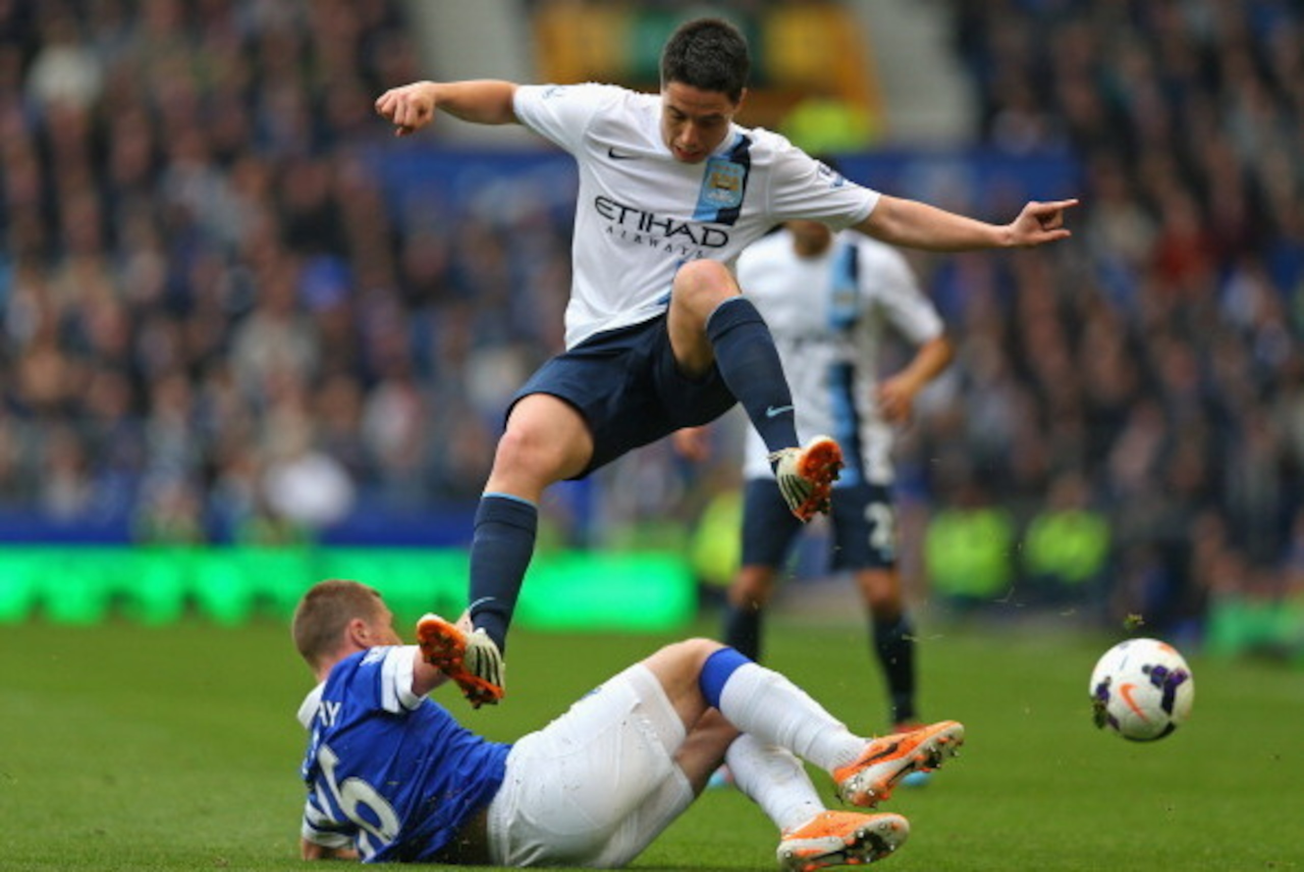 LIVERPOOL, ENGLAND - MAY 03:  Samir Nasri of Manchester City hurdles the tackle of James McCarthy of Everton during the Barclays Premier League match between Everton and Manchester City at Goodison Park on May 3, 2014 in Liverpool, England.  (Photo by Cli