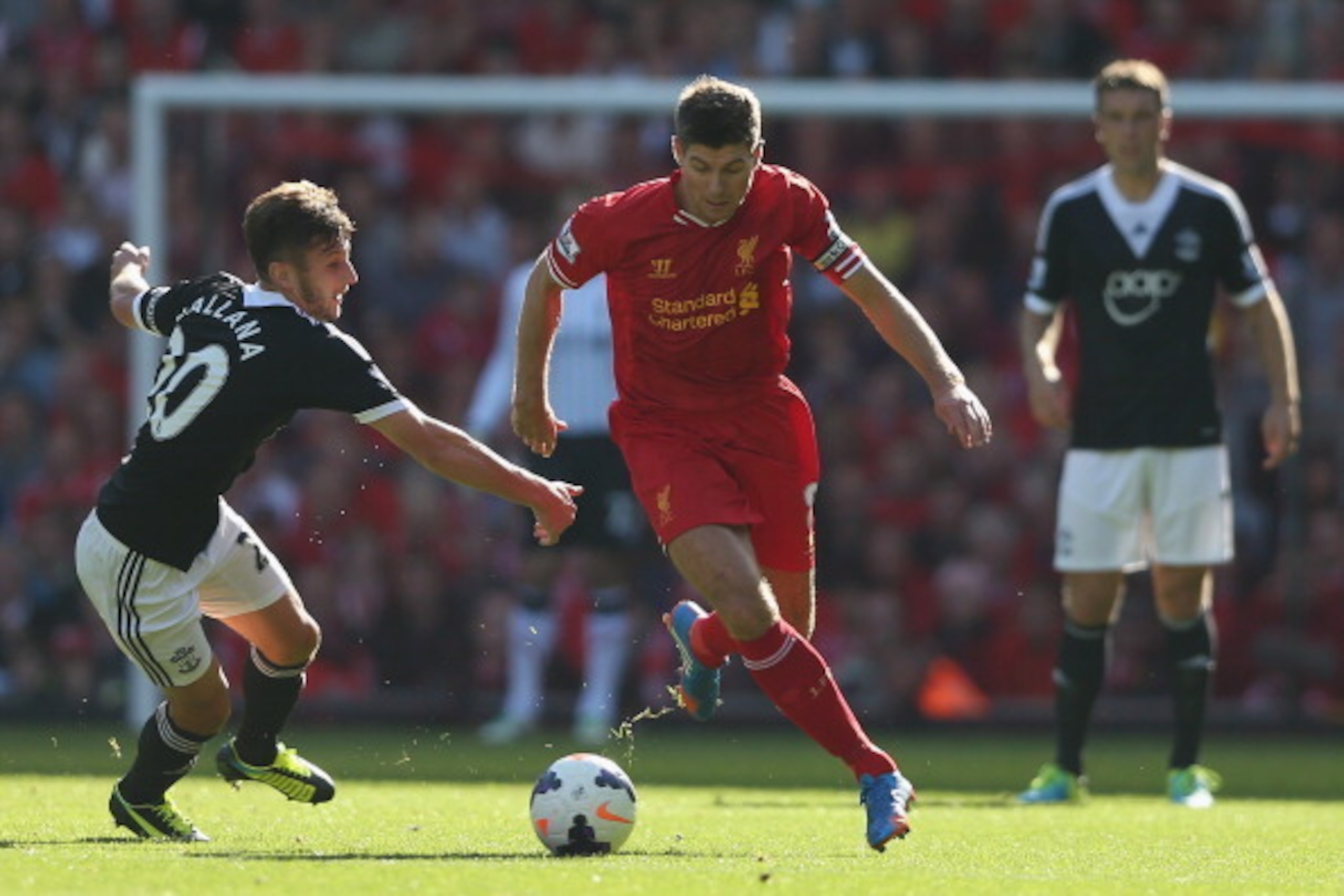 LIVERPOOL, ENGLAND - SEPTEMBER 21: Steven Gerrard of Liverpool moves away from Adam Lallana of Southampton during the Barclays Premier League match between Liverpool and Southampton at Anfield on September 21, 2013 in Liverpool, England.  (Photo by Clive 