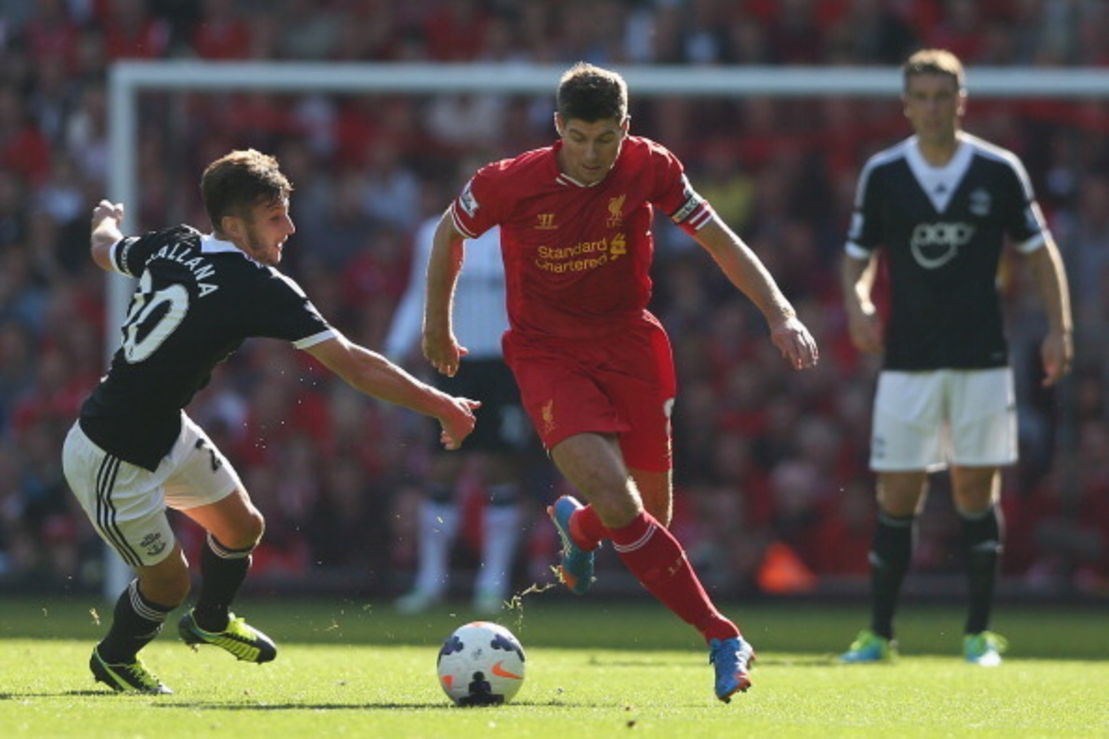 LIVERPOOL, ENGLAND - SEPTEMBER 21: Steven Gerrard of Liverpool moves away from Adam Lallana of Southampton during the Barclays Premier League match between Liverpool and Southampton at Anfield on September 21, 2013 in Liverpool, England.  (Photo by Clive 