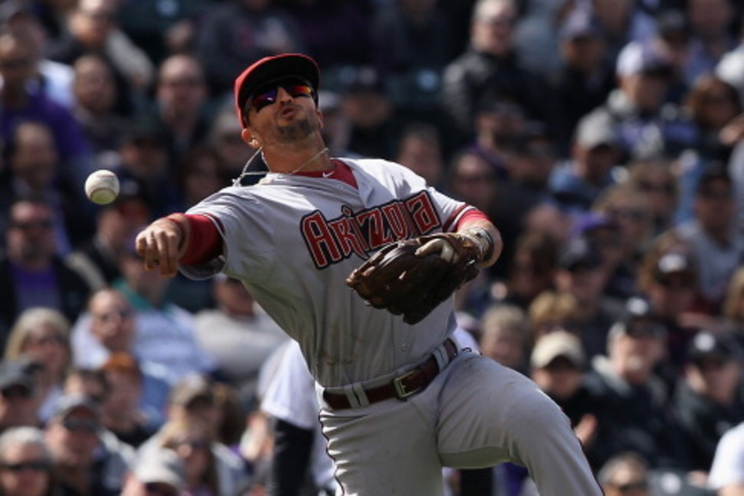 DENVER, CO - APRIL 04:  Third baseman Martin Prado #14 of the Arizona Diamondbacks throws out a runner against the Colorado Rockies during the home opener at Coors Field on April 4, 2014 in Denver, Colorado. The Rockies defeated the Diamondbacks 12-2.  (P