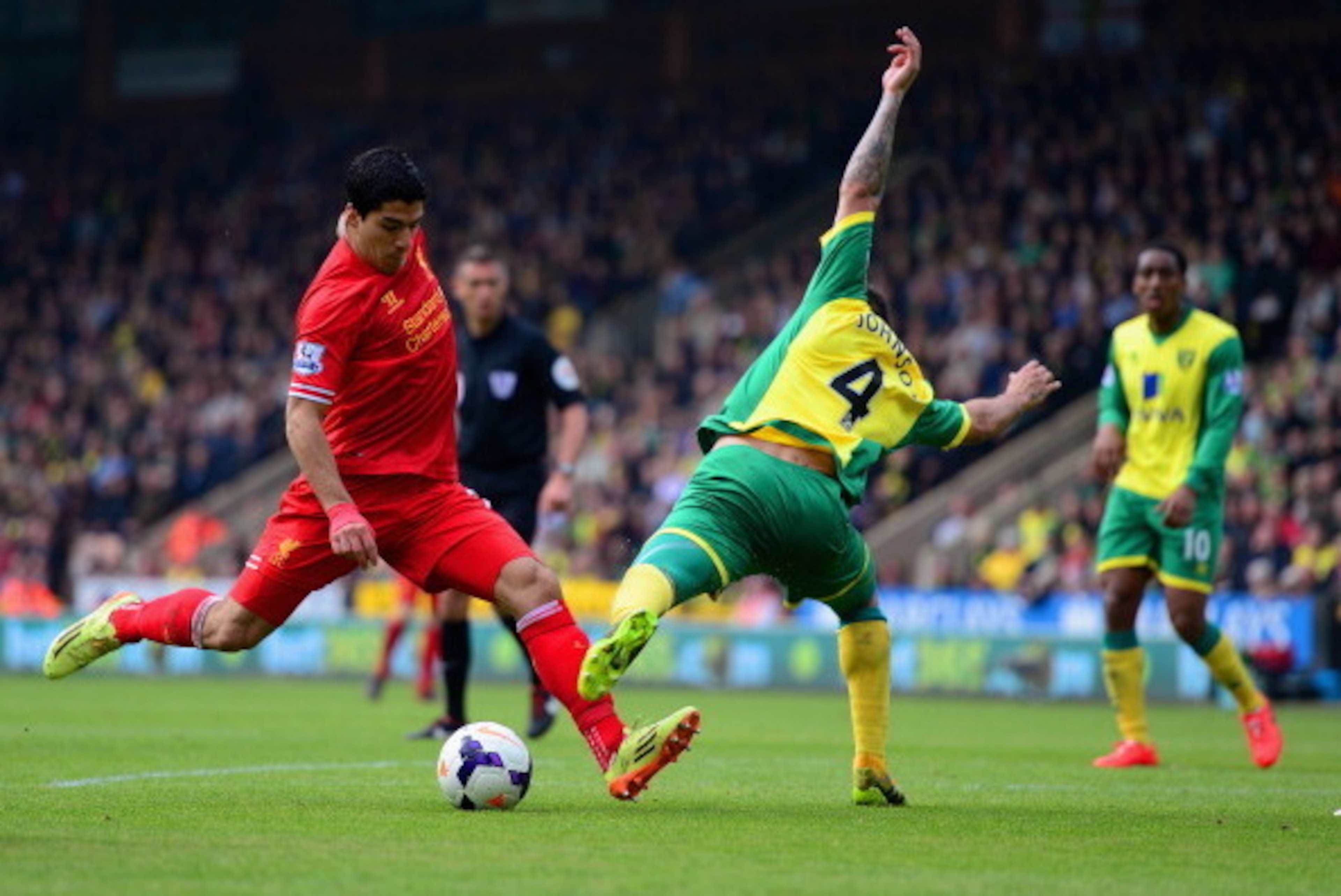 NORWICH, ENGLAND - APRIL 20:  Luis Suarez of Liverpool is challenged by Bradley Johnson of Norwich City during the Barclays Premier League match between Norwich City and Liverpool at Carrow Road on April 20, 2014 in Norwich, England.  (Photo by Jamie McDo