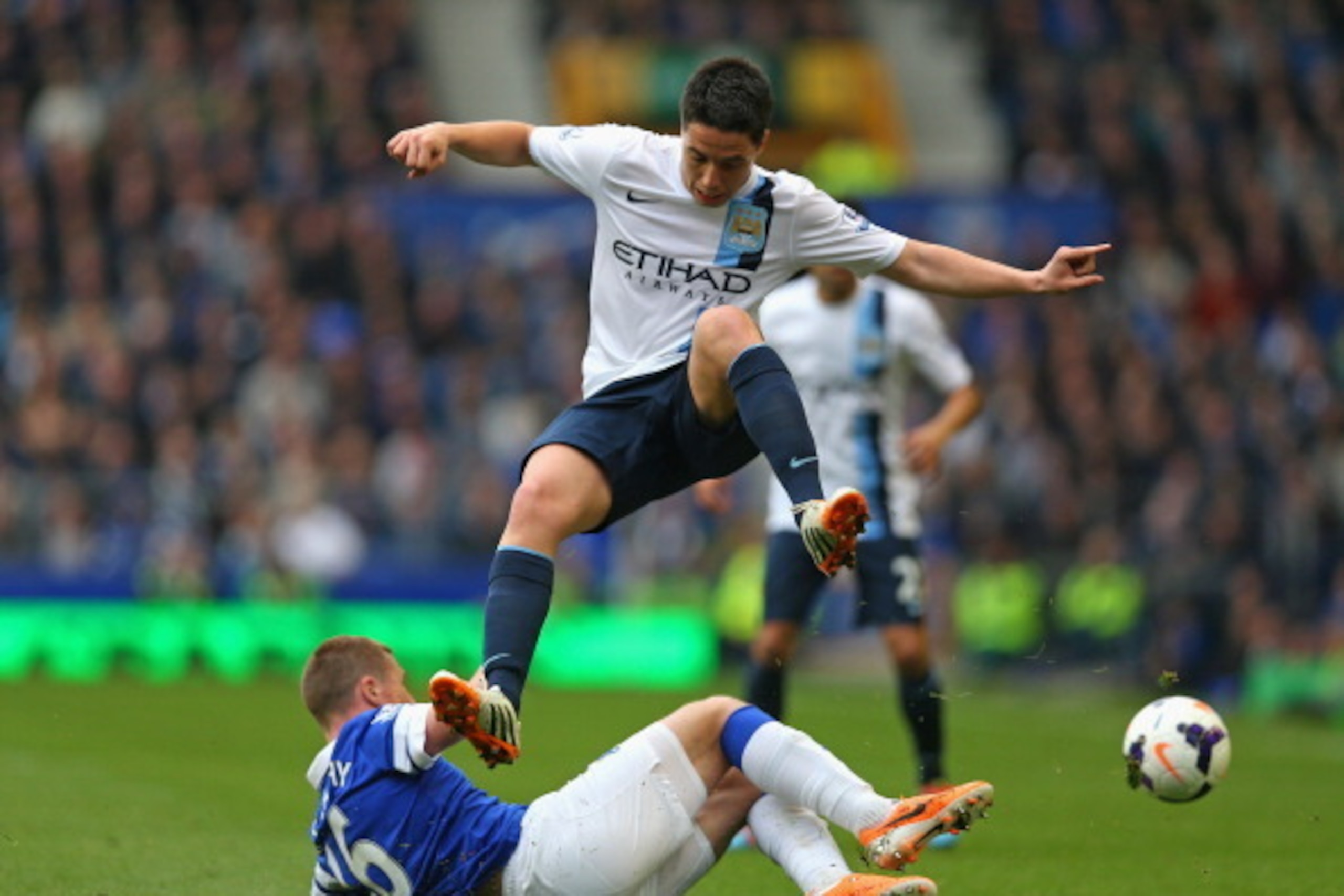 LIVERPOOL, ENGLAND - MAY 03:  Samir Nasri of Manchester City hurdles the tackle of James McCarthy of Everton during the Barclays Premier League match between Everton and Manchester City at Goodison Park on May 3, 2014 in Liverpool, England.  (Photo by Cli