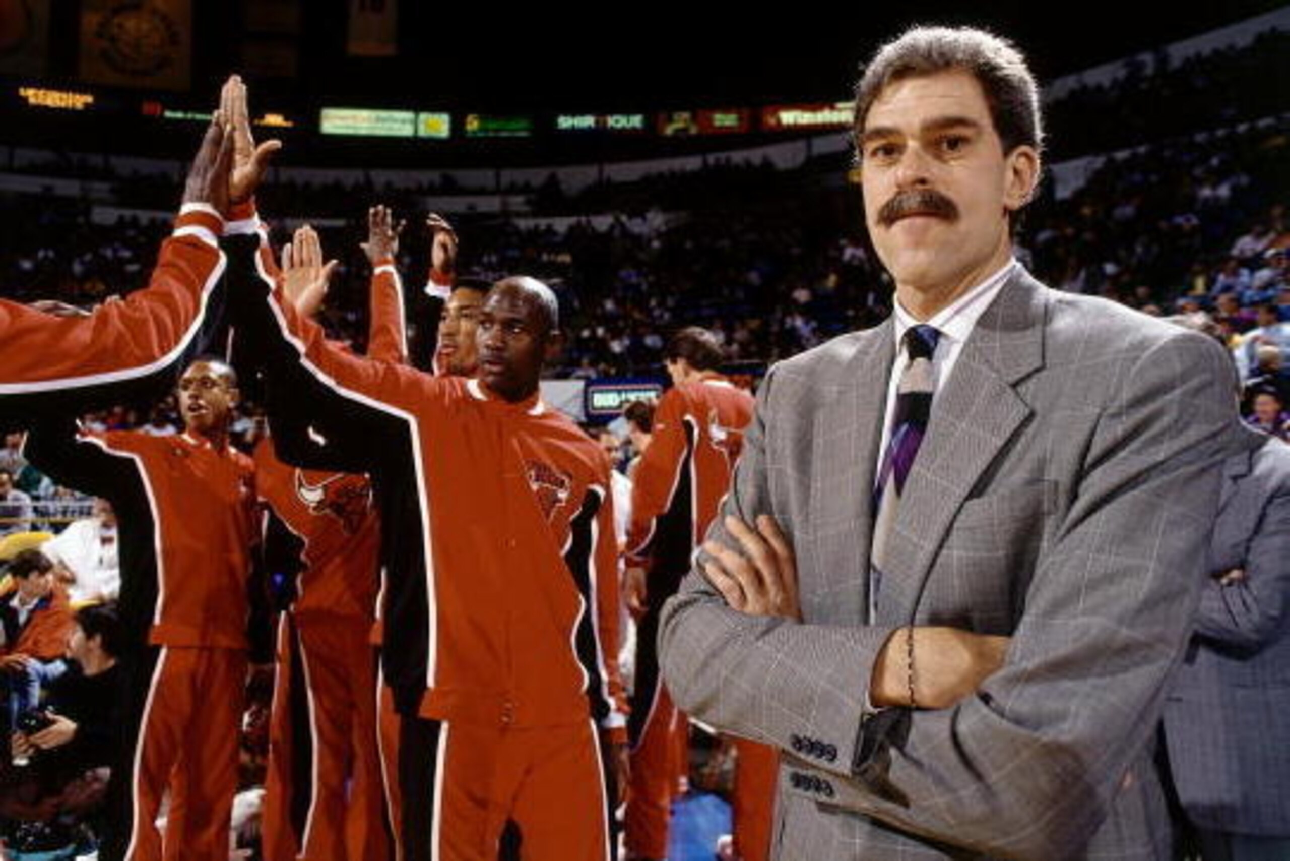 CHICAGO - 1990:  Head Coach Phil Jackson of the Chicago Bulls looks on as Michael Jordan gets introduced prior to a game circa 1990 at the United Center in Chicago, Illinois. NOTE TO USER: User expressly acknowledges and agrees that, by downloading and/or