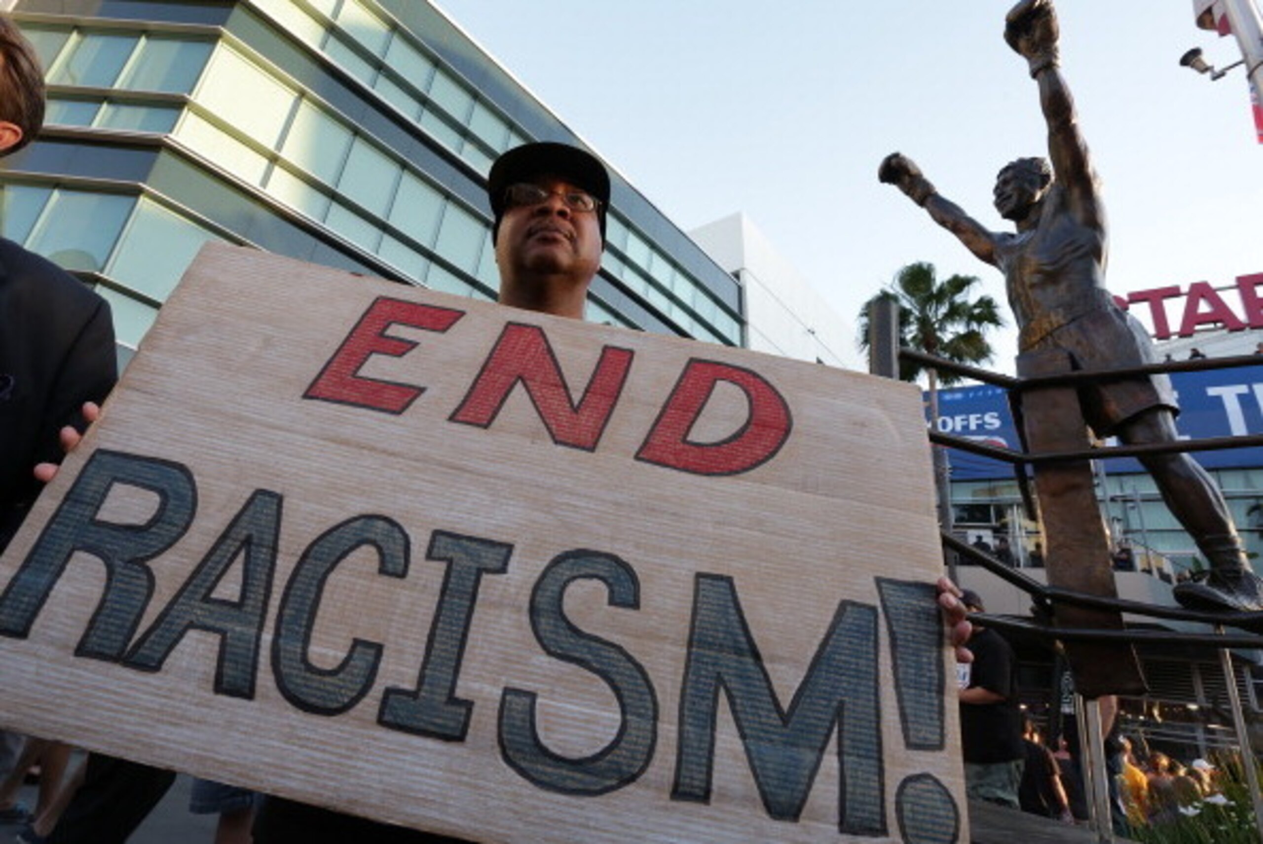 LOS ANGELES, CA -  APRIL 29:   Dexter McLeod holds a sign protesting racist comments made by L.A. Clippers owner Donald Sterling outside Staples Center before a playoff game on April 29, 2014 in Los Angeles, California. Clippers owner Donald Sterling was 