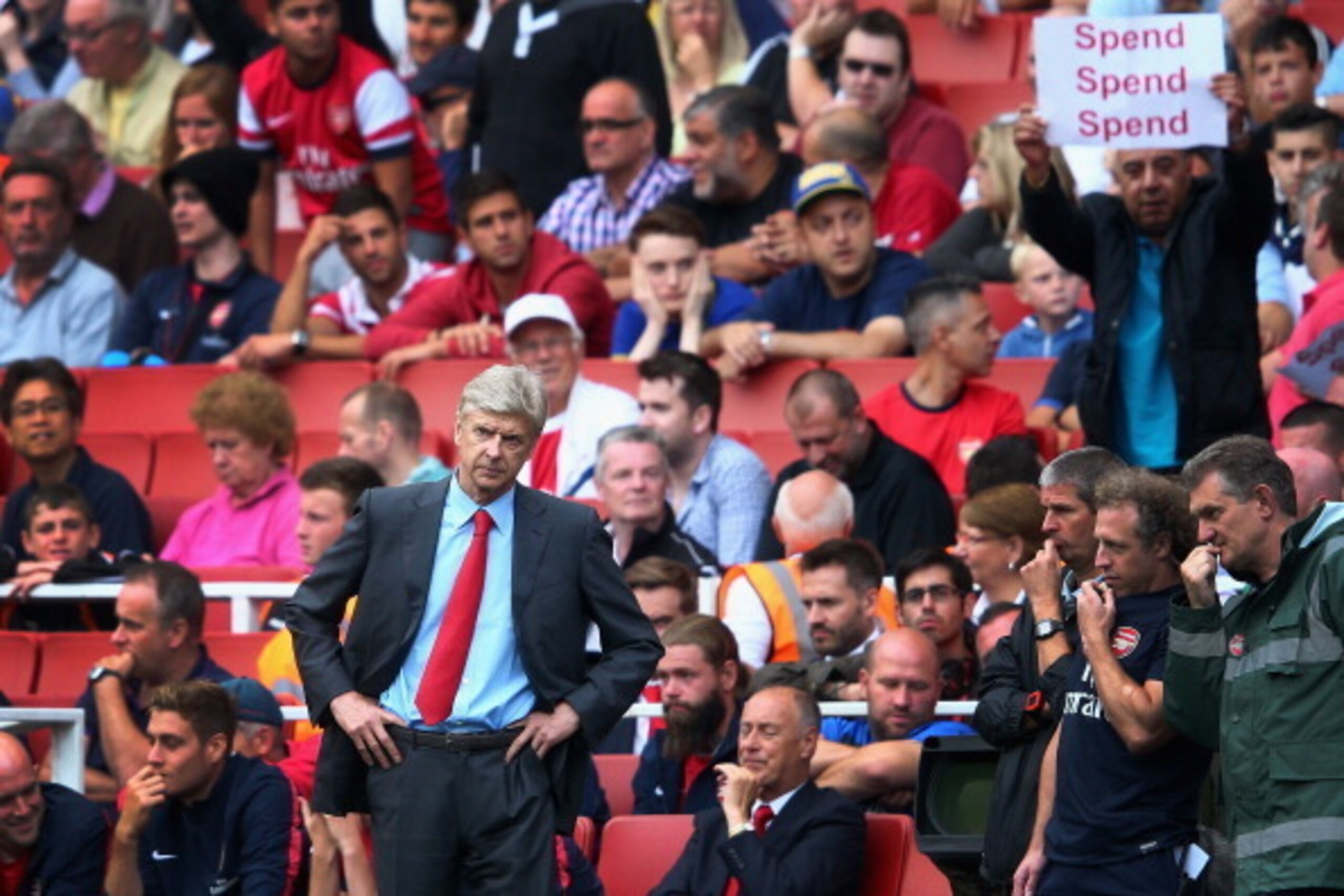 LONDON, ENGLAND - AUGUST 17:  Arsene Wenger of Arsenal looks on as a fan behind makes his feelings known during the Barclays Premier League match between Arsenal and Aston Villa at Emirates Stadium on August 17, 2013 in London, England. (Photo by Clive Ma