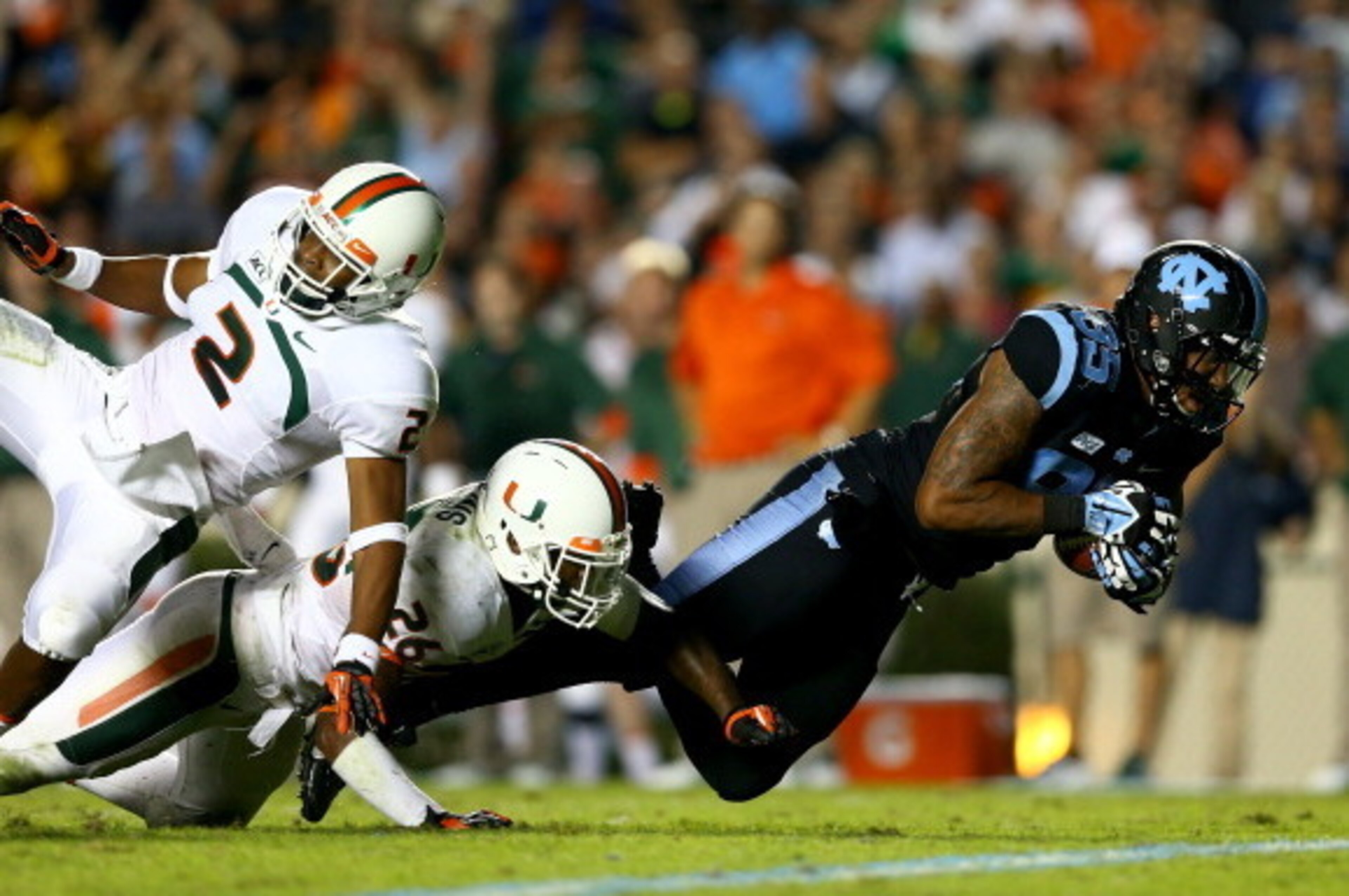 CHAPEL HILL, NC - OCTOBER 17: Teammates Rayshawn Jenkins #26 of the Miami Hurricanes and Deon Bush #2 watch as Eric Ebron #85 of the North Carolina Tar Heels makes a catch during their game at Kenan Stadium on October 17, 2013 in Chapel Hill, North Carol CHAPEL HILL, NC - OCTOBER 17: Teammates Rayshawn Jenkins #26 of the Miami Hurricanes and Deon Bush #2 watch as Eric Ebron #85 of the North Carolina Tar Heels makes a catch during their game at Kenan Stadium on October 17, 2013 in Chapel Hill, North Carol