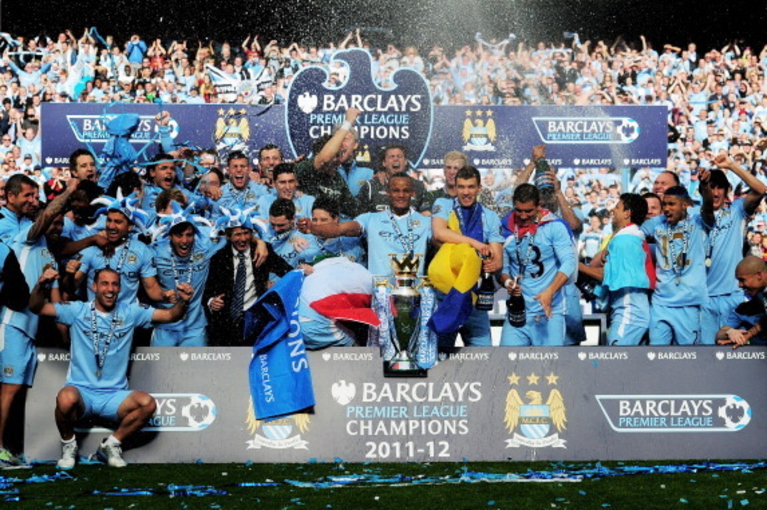 MANCHESTER, ENGLAND - MAY 13:  The Manchester City players celebrate with the trophy following the Barclays Premier League match between Manchester City and Queens Park Rangers at the Etihad Stadium on May 13, 2012 in Manchester, England.  (Photo by Shaun
