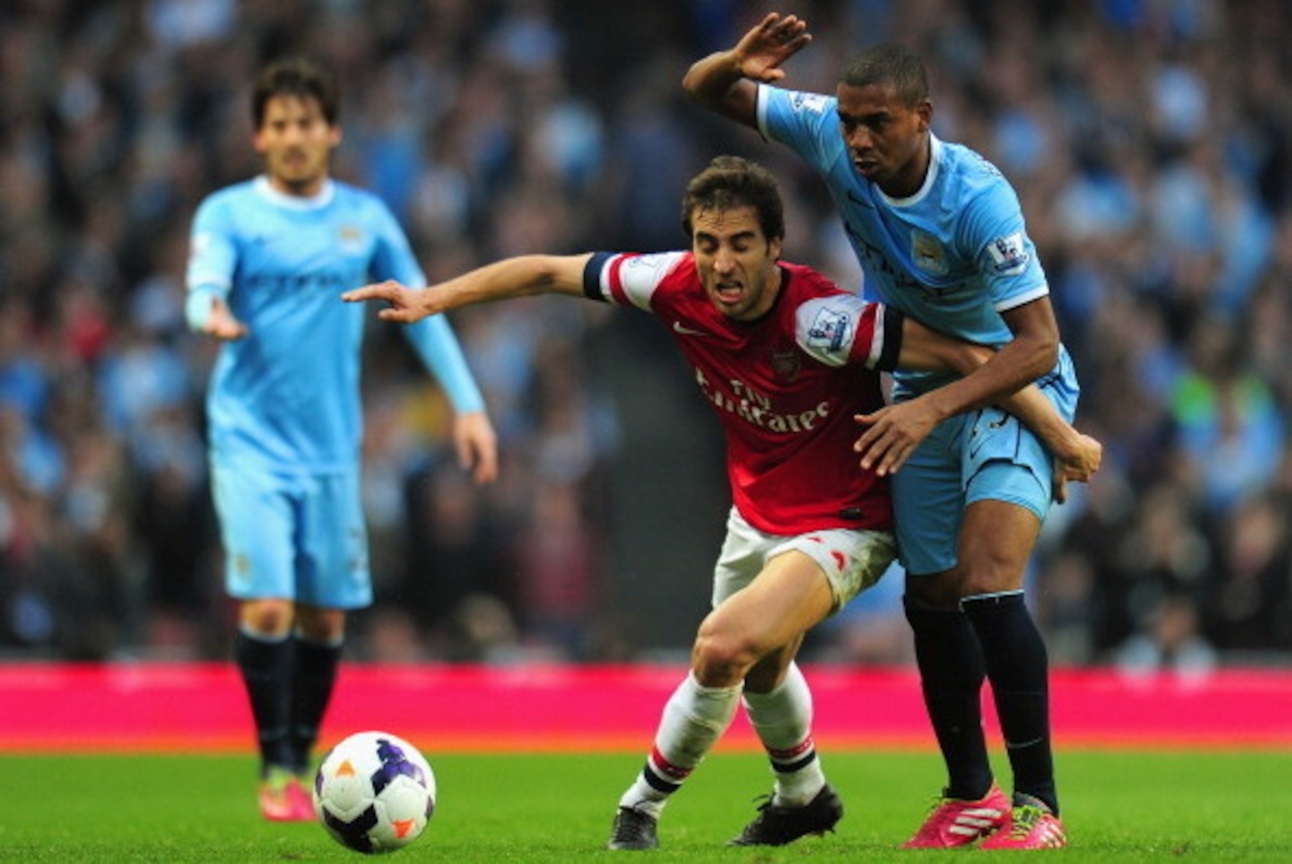 LONDON, ENGLAND - MARCH 29: Mathieu Flamini of Arsenal holds off Fernandinho of Manchester City  during the Barclays Premier League match between Arsenal and Manchester City at Emirates Stadium on March 29, 2014 in London, England.  (Photo by Shaun Botter