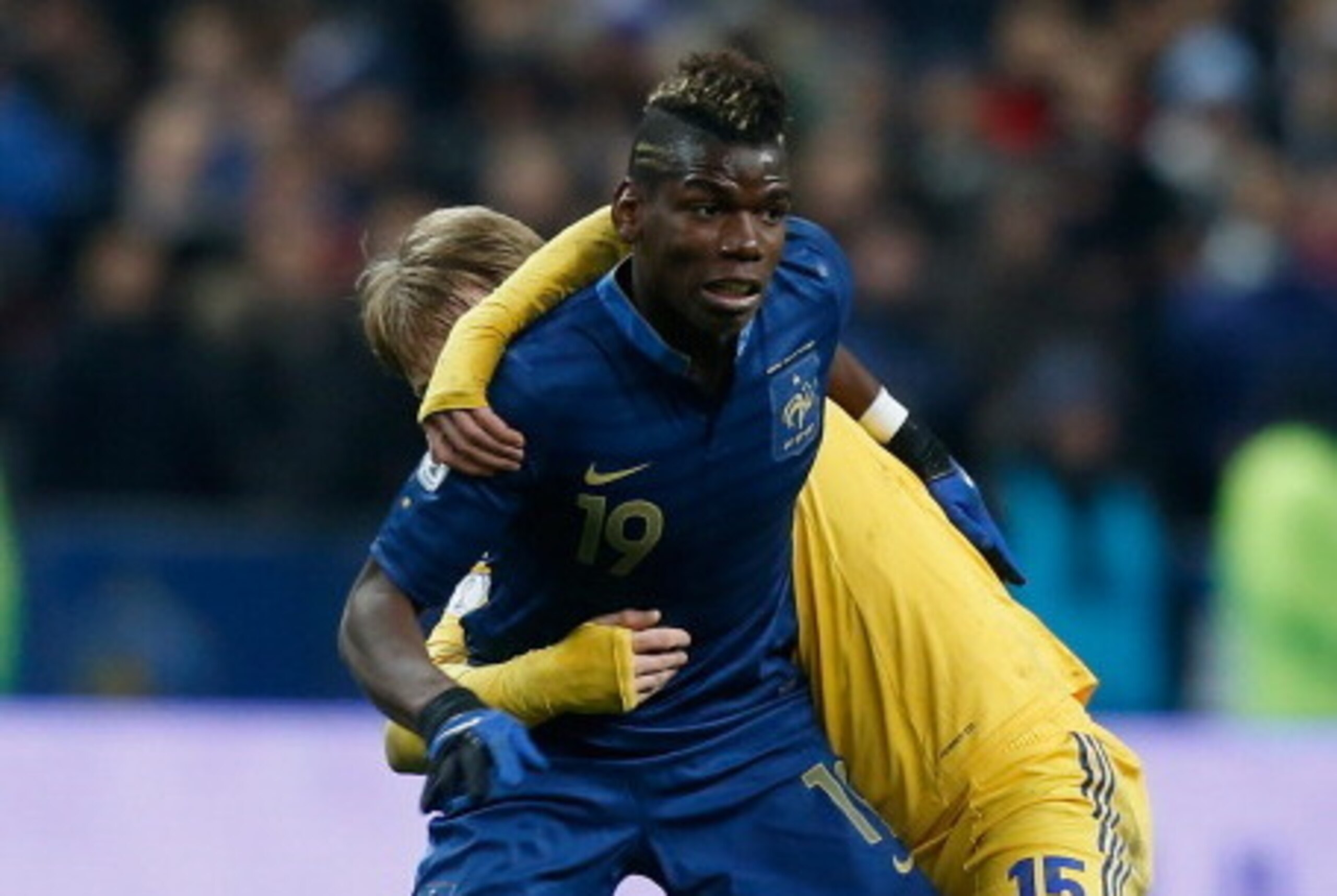PARIS, FRANCE - NOVEMBER 19:  Paul Pogba of France is tackled by Roman Bezus of Ukraine during the FIFA 2014 World Cup Qualifier 2nd Leg Playoff between France and Ukraine at the Stade de France on November 19, 2013 in Paris, France.  (Photo by Harry Enge