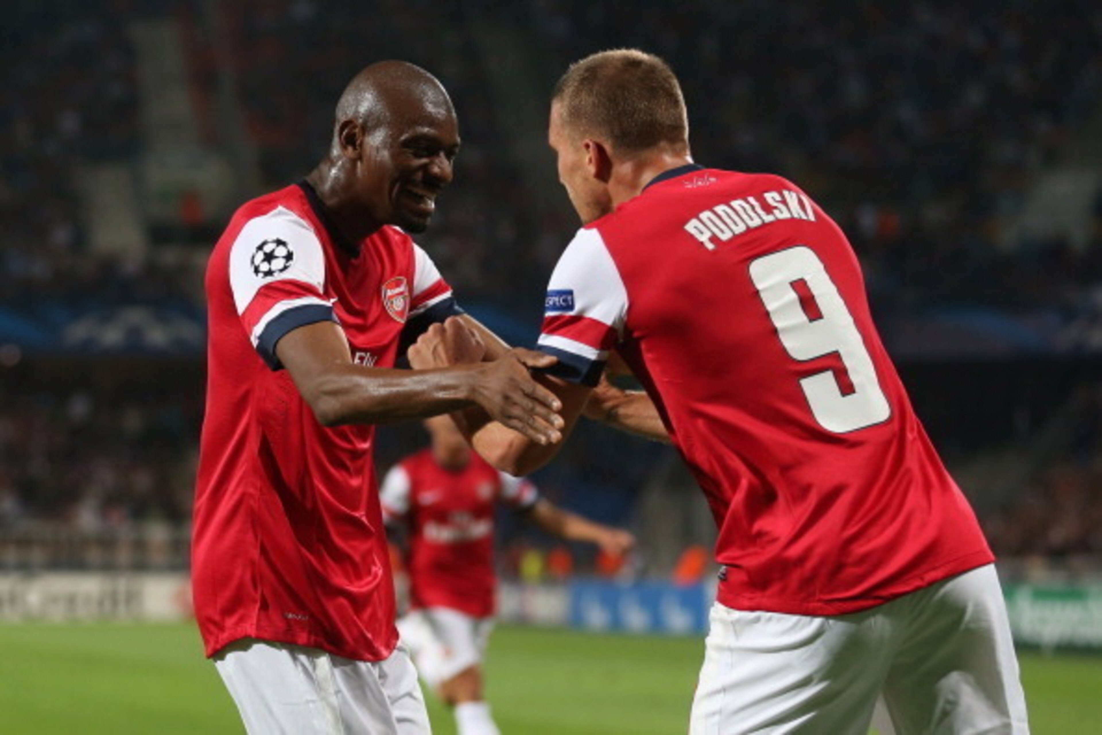 MONTPELLIER, FRANCE - SEPTEMBER 18:  Abou Diaby of Arsenal congratulates Lukas Podolski of Arsenal celebrates scoring his teams first goal during the UEFA Champions League match between Montpellier Herault SC and Arsenal at Stade de la Mosson on September