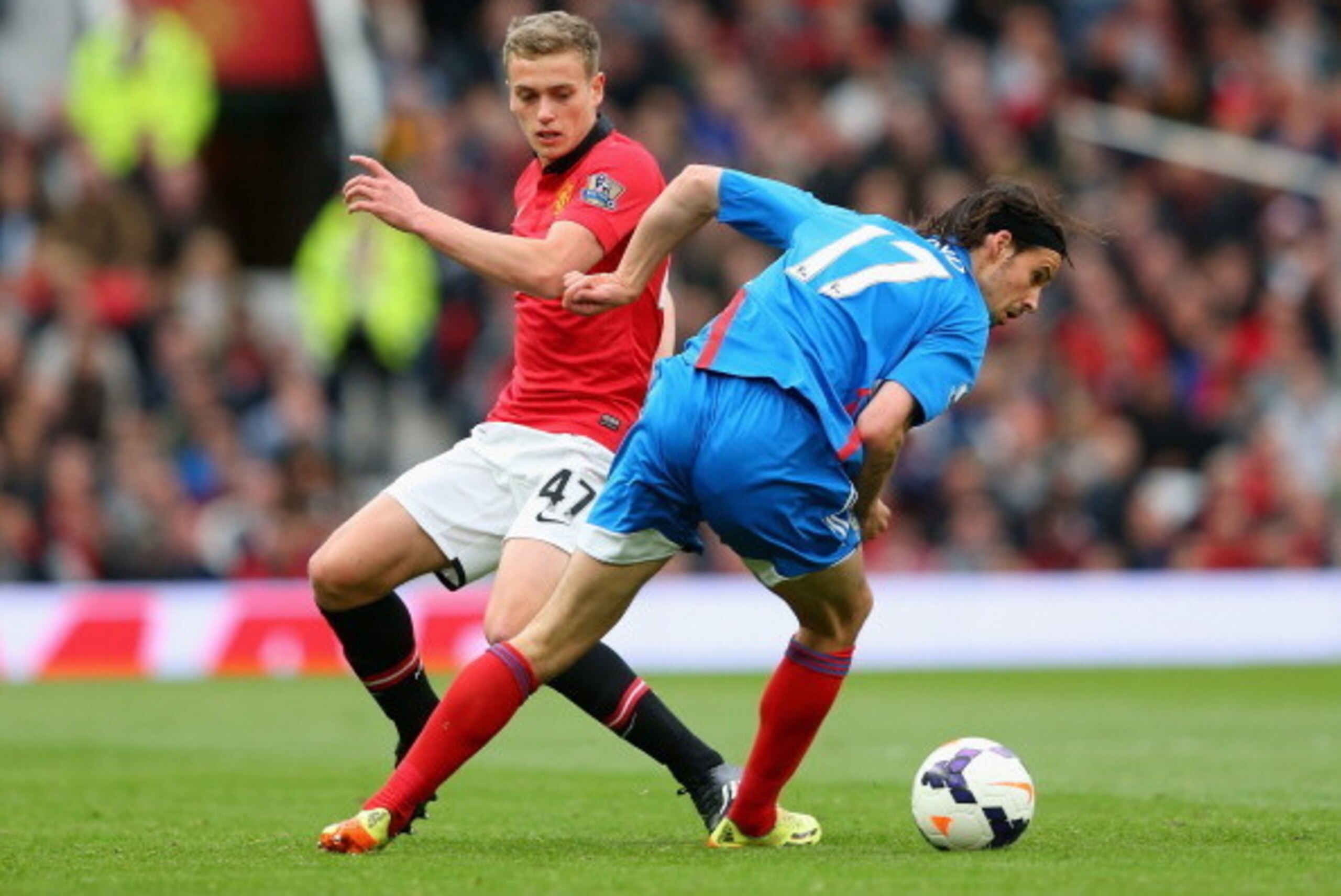 MANCHESTER, ENGLAND - MAY 06:  James Wilson of Manchester United competes with George Boyd of Hull City during the Barclays Premier League match between Manchester United and Hull City at Old Trafford on May 6, 2014 in Manchester, England.  (Photo by Alex