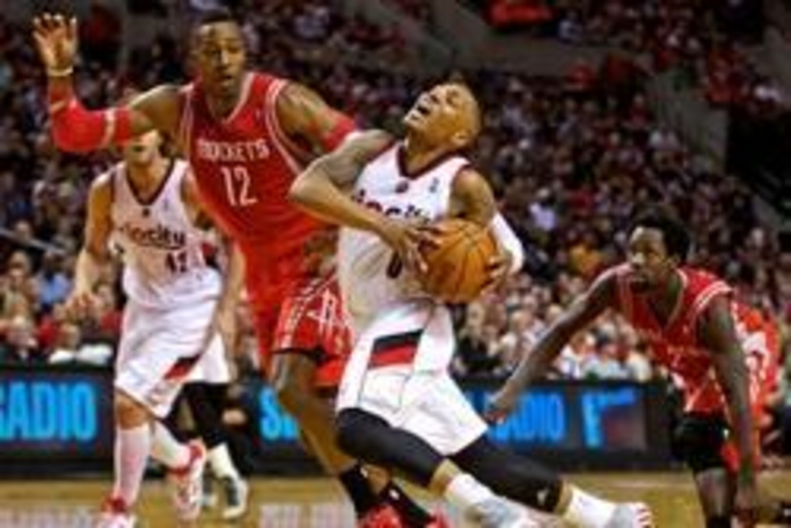 Apr 25, 2014; Portland, OR, USA; Portland Trail Blazers guard Damian Lillard (0) is bumped by Houston Rockets center Dwight Howard (12) during the second quarter in game three of the first round of the 2014 NBA Playoffs at the Moda Center. Mandatory Credi