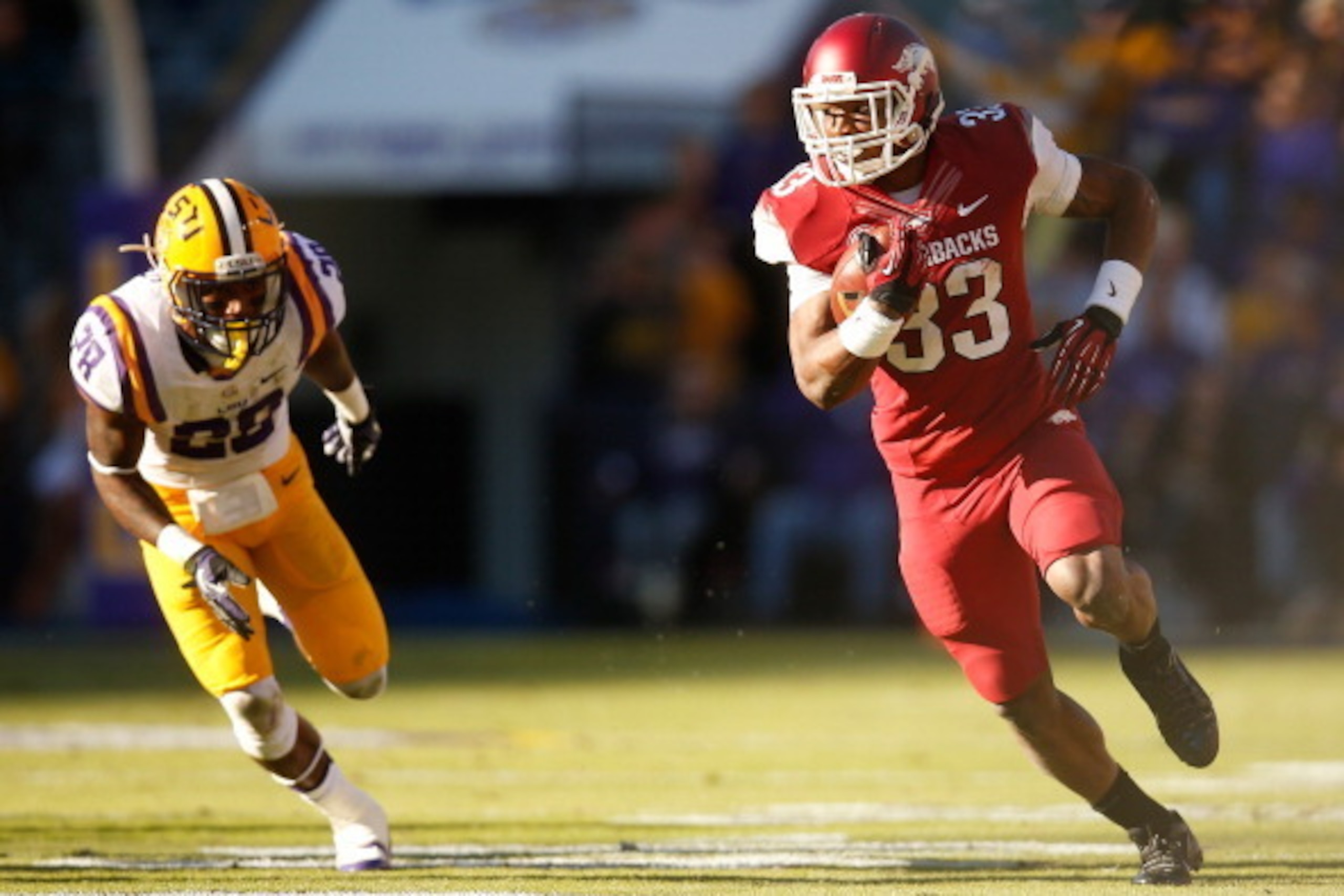 BATON ROUGE, LA - NOVEMBER 29:  Korliss Marshall #33 of the Arkansas Razorbacks runs past Jalen Mills #28 of the LSU Tigers at Tiger Stadium on November 29, 2013 in Baton Rouge, Louisiana.  (Photo by Chris Graythen/Getty Images)