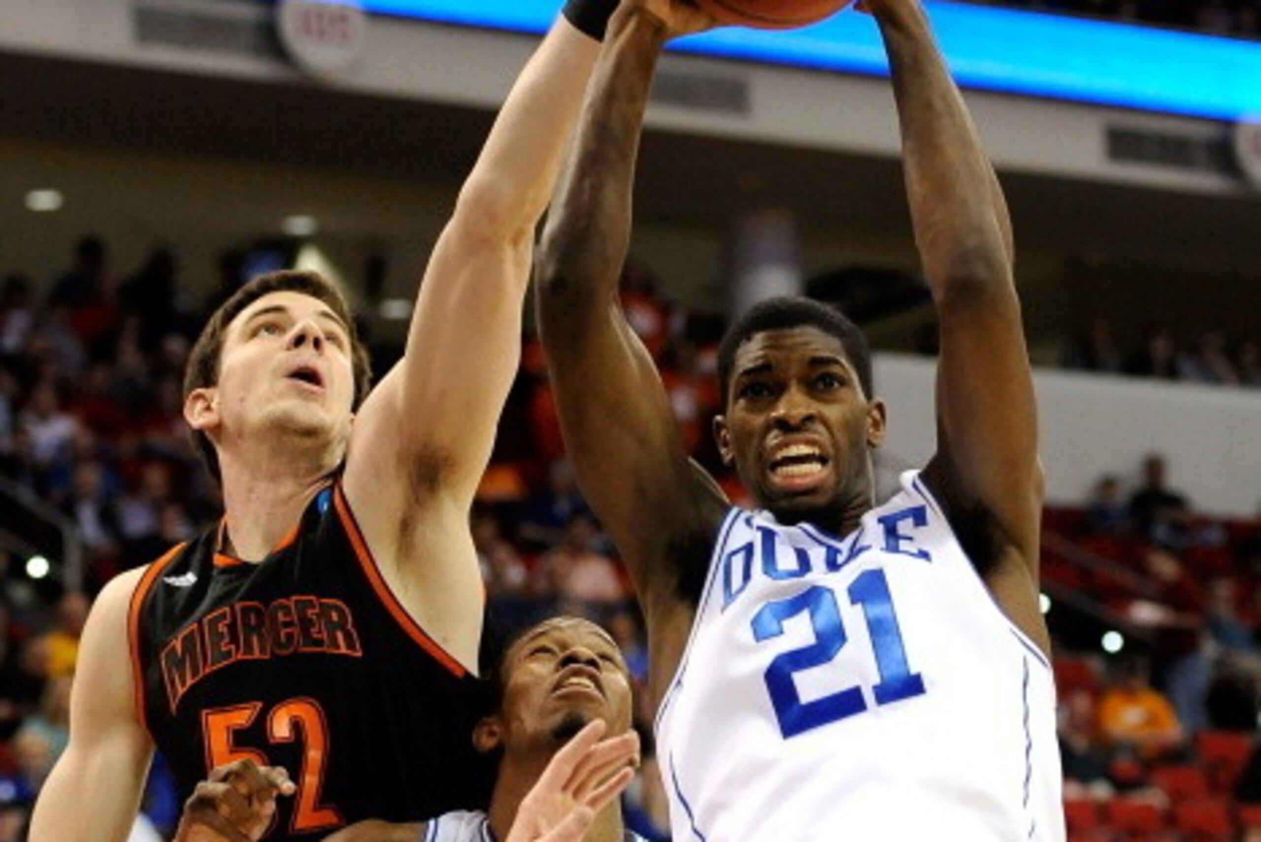 RALEIGH, NC - MARCH 21:  Amile Jefferson #21 of the Duke Blue Devils rebounds the ball alongside Daniel Coursey #52 of the Mercer Bears in the first half in the second round of the 2014 NCAA Men's Basketball Tournament at PNC Arena on March 21, 2014 in Ra