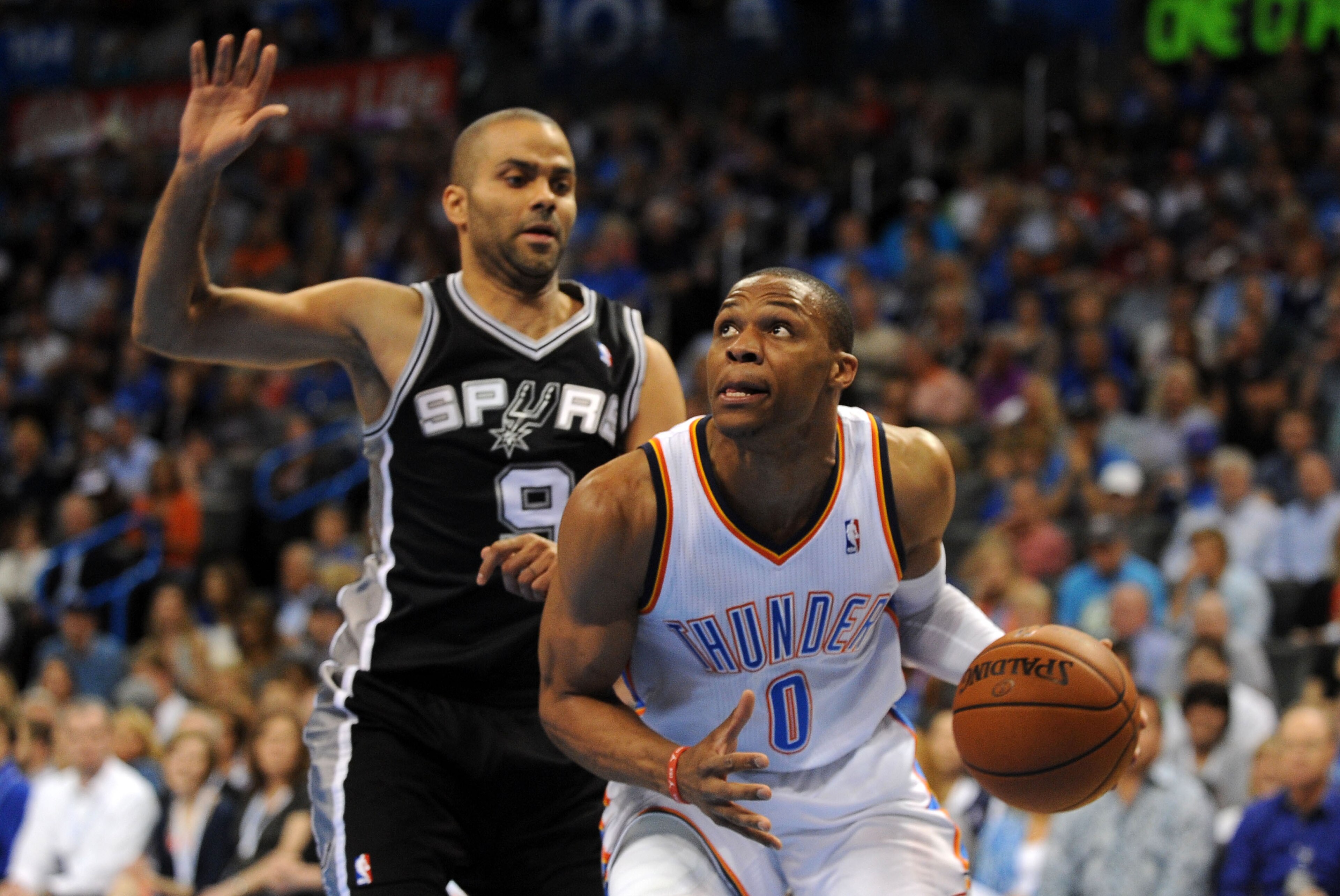 Apr 3, 2014; Oklahoma City, OK, USA; Oklahoma City Thunder guard Russell Westbrook (0) drives to the basket against San Antonio Spurs guard Tony Parker (9) during the first quarter at Chesapeake Energy Arena. Mandatory Credit: Mark D. Smith-USA TODAY Spor