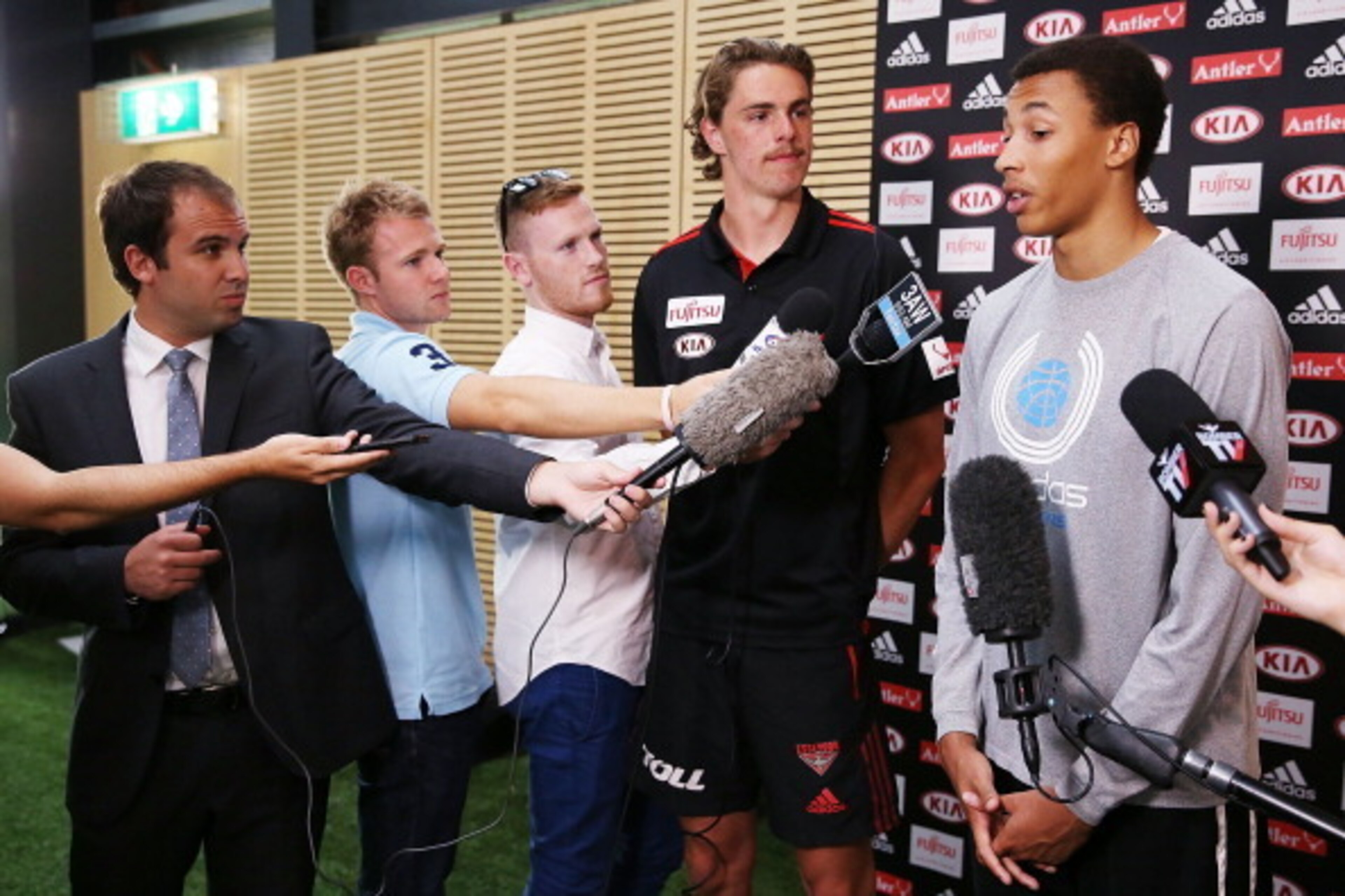 MELBOURNE, AUSTRALIA - FEBRUARY 14:  Young Australian basketball player Dante Exum (R) and Joe Daniher of the Bombers  speak during an Essendon Bombers AFL media session at True Value Solar Centre on February 14, 2014 in Melbourne, Australia.  (Photo by M