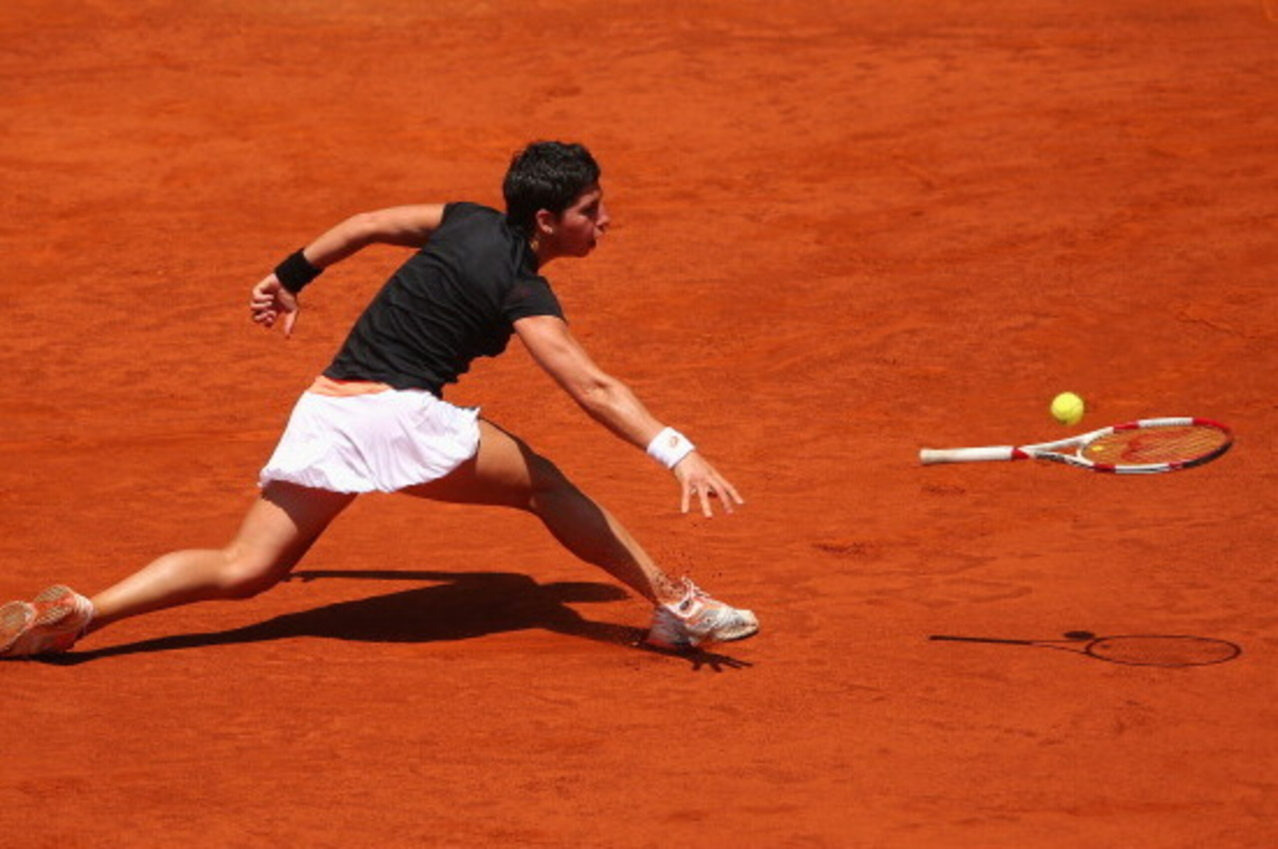 MADRID, SPAIN - MAY 08:  Carla Suarez Navarro of Spain throws her racket at the ball after failing to reach a backhand against Serena Williams of the United States in their third round match during day six of the Mutua Madrid Open tennis tournament at the