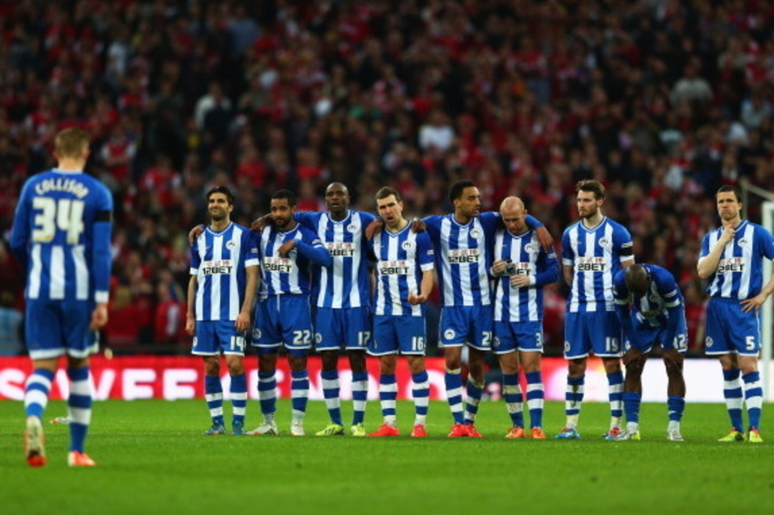 LONDON, ENGLAND - APRIL 12:  Jordi Gomez of Wigan Athletic (L) and team mates look on during the penalty shoot out during the FA Cup Semi-Final match between Wigan Athletic and Arsenal at Wembley Stadium on April 12, 2014 in London, England.  (Photo by Mi