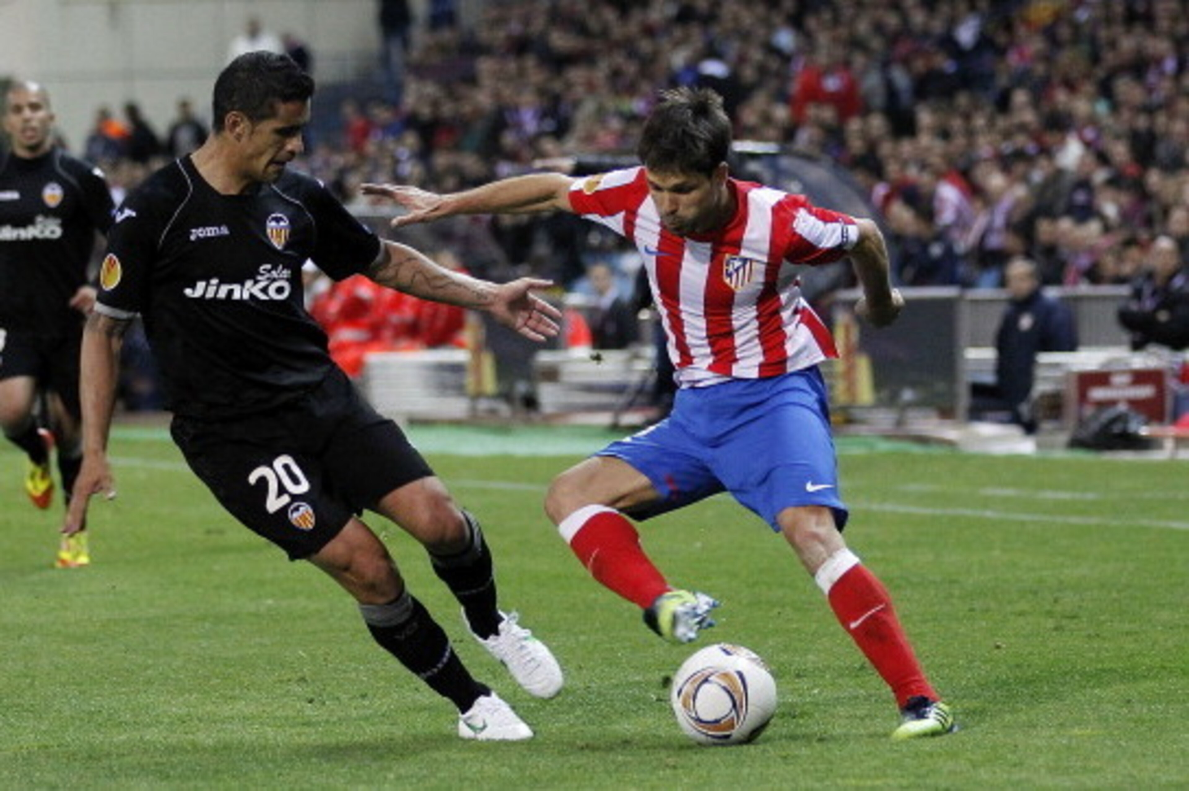 MADRID, SPAIN - APRIL 19: Diego Ribas of Atletico Madrid duels for the ball with Ricardo Costa of Valencia during the UEFA Europa League Semi Final first leg match between Atletico Madrid and Valencia at Vicente Calderon stadium on April 19, 2012 in Madri