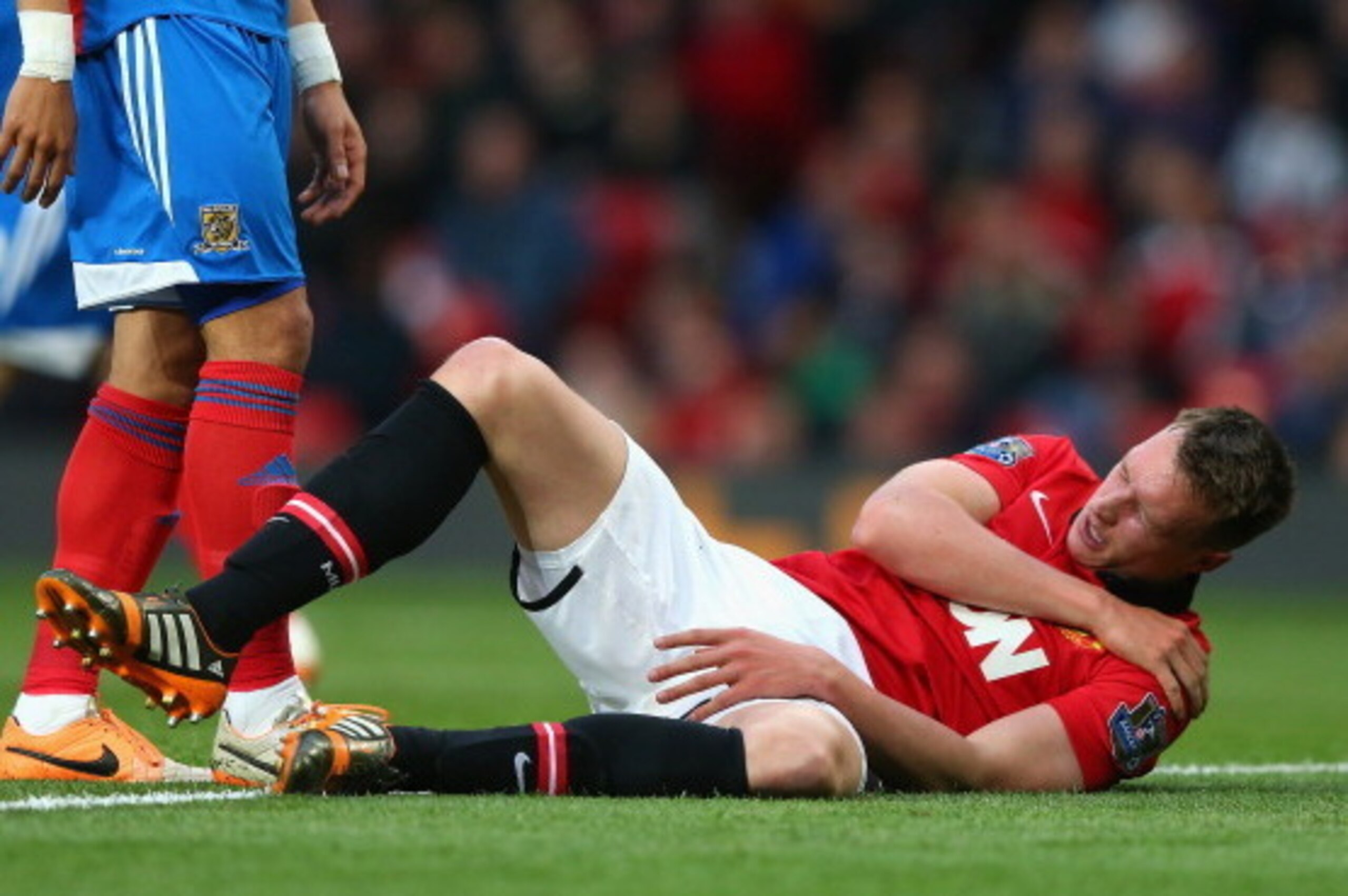 MANCHESTER, ENGLAND - MAY 06:  Phil Jones of Manchester United holds his shoulder after sustaining an injury during the Barclays Premier League match between Manchester United and Hull City at Old Trafford on May 6, 2014 in Manchester, England.  (Photo by