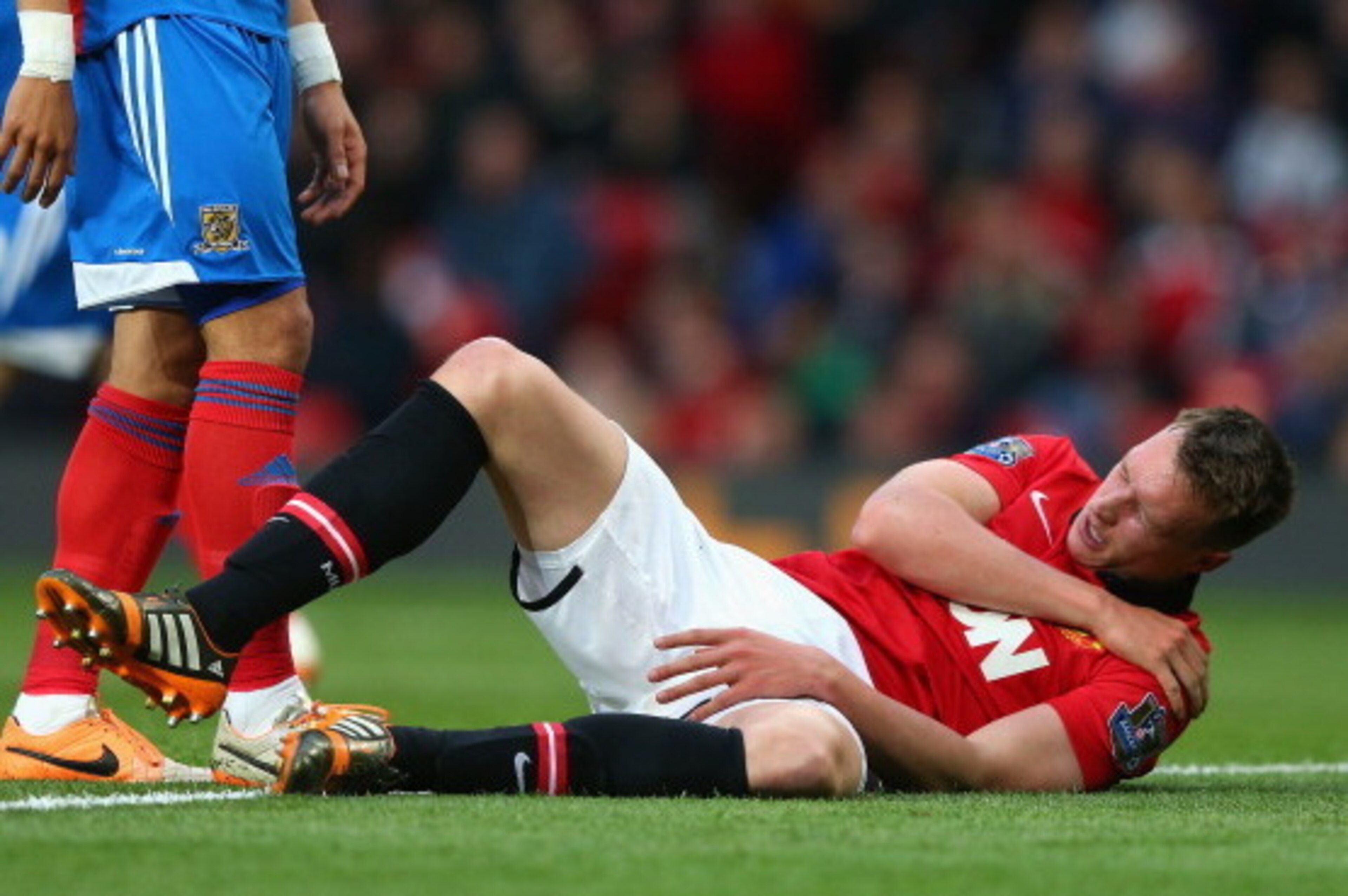 MANCHESTER, ENGLAND - MAY 06:  Phil Jones of Manchester United holds his shoulder after sustaining an injury during the Barclays Premier League match between Manchester United and Hull City at Old Trafford on May 6, 2014 in Manchester, England.  (Photo by