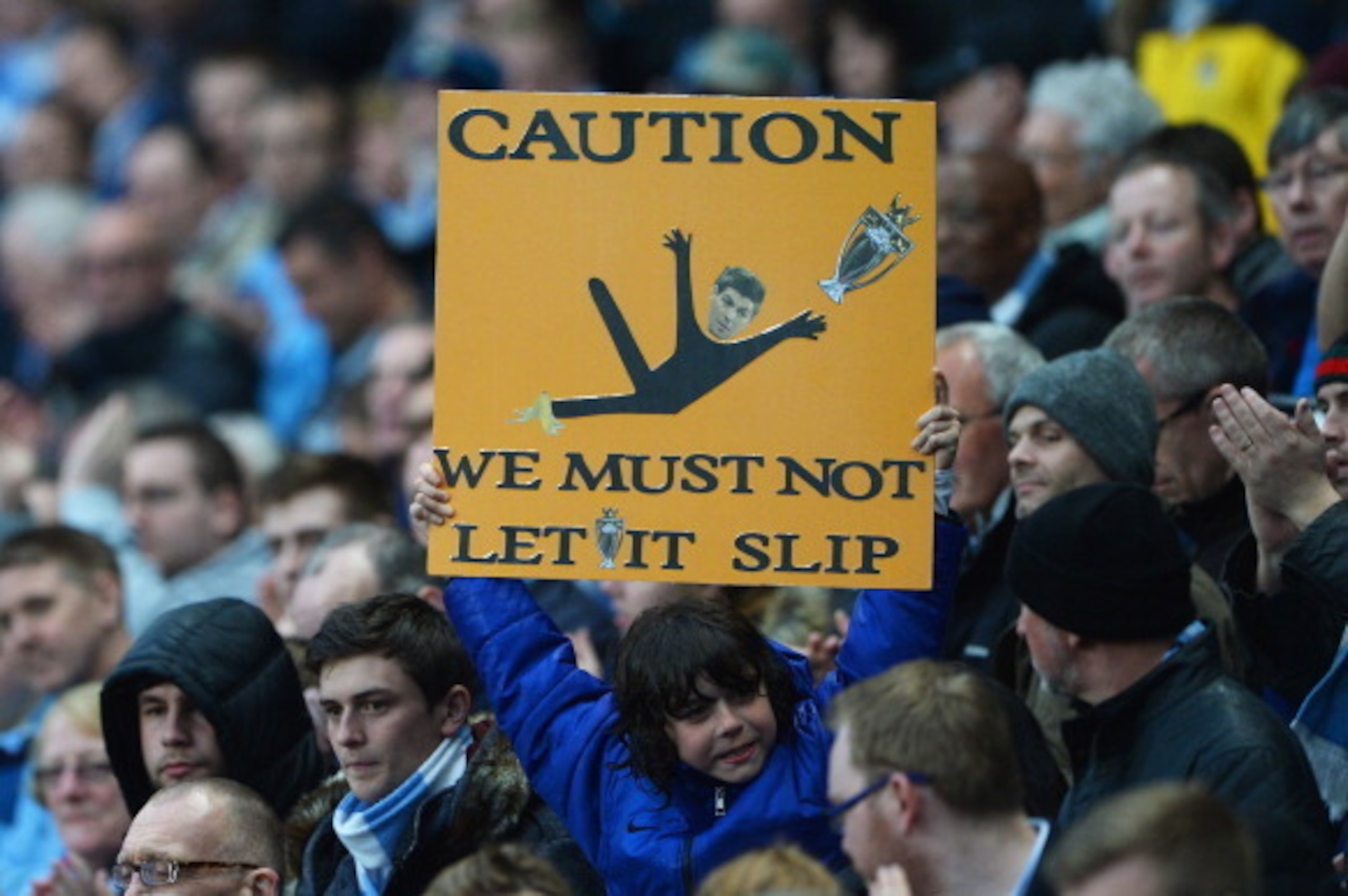 MANCHESTER, ENGLAND - MAY 07: A Manchester City fan holds a message for his team referencing Steven Gerrard's slip against Chelsea during the Barclays Premier League match between Manchester City and Aston Villa at Etihad Stadium on May 7, 2014 in Manches