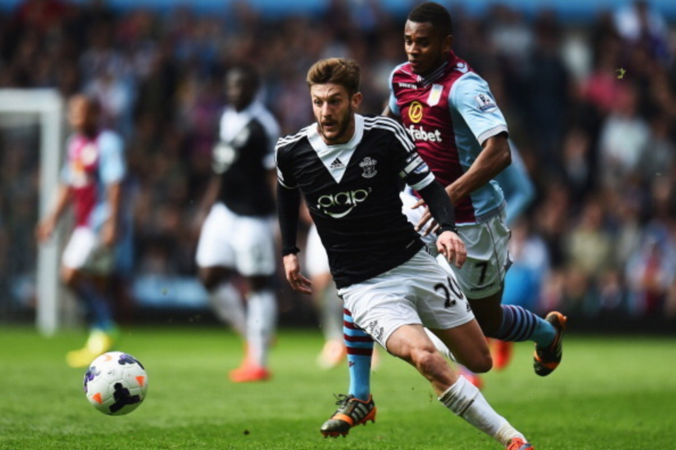 BIRMINGHAM, ENGLAND - APRIL 19:  Leandro Bacuna (rear) of Aston Villa chases down Adam Lallana (front) of Southampton for the ball during the Barclays Premier League match between Aston Villa and Southampton at Villa Park on April 19, 2014 in Birmingham, 