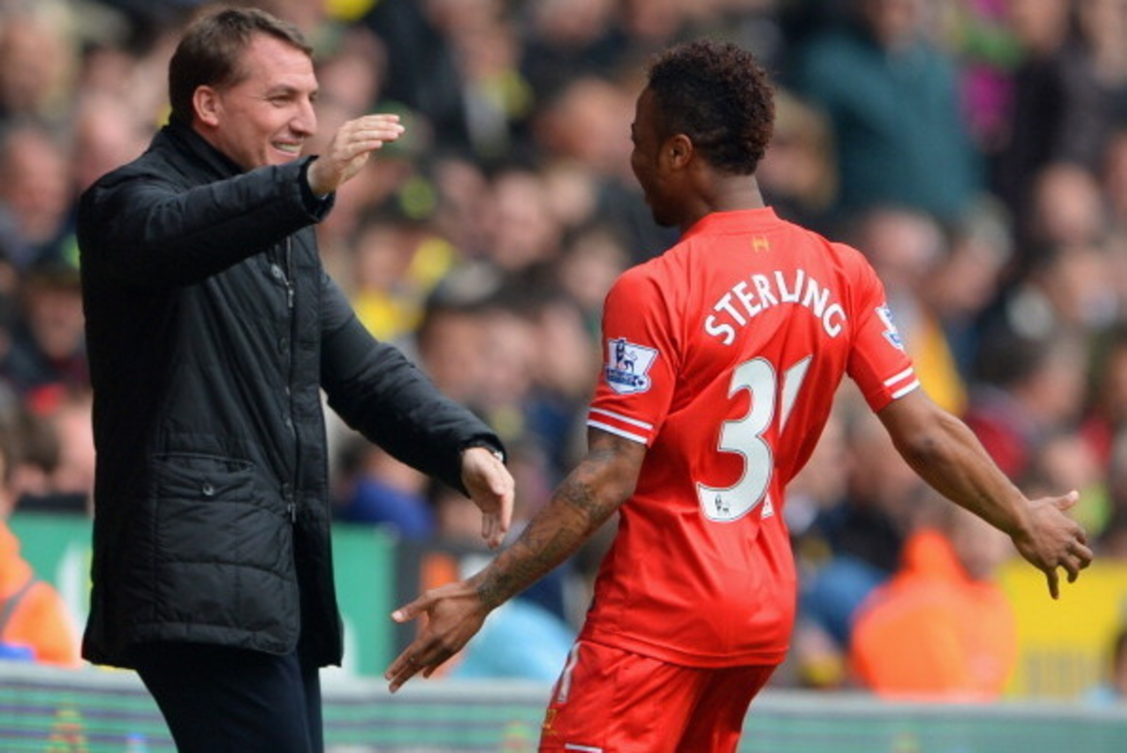 NORWICH, ENGLAND - APRIL 20:  Raheem Sterling of Liverpool celebrates scoring the opening goal with Manager Brendan Rodgers of Liverpool during the Barclays Premier League match between Norwich City and Liverpool at Carrow Road on April 20, 2014 in Norwic