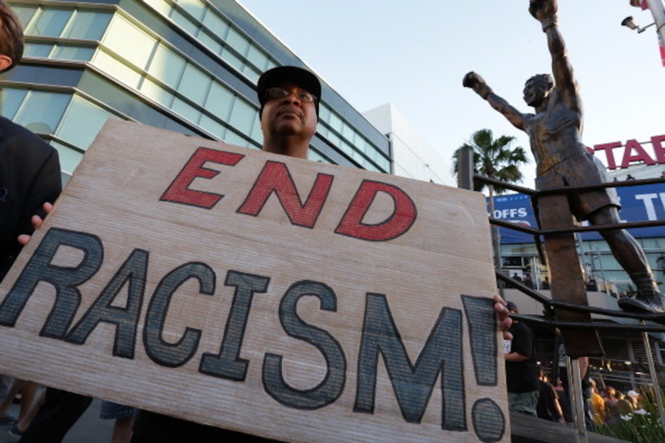LOS ANGELES, CA -  APRIL 29:   Dexter McLeod holds a sign protesting racist comments made by L.A. Clippers owner Donald Sterling outside Staples Center before a playoff game on April 29, 2014 in Los Angeles, California. Clippers owner Donald Sterling was 