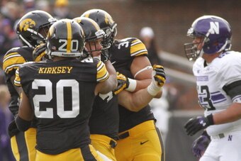 IOWA CITY, IOWA - OCTOBER 26:  Linebacker James Morris #44 of the Iowa Hawkeyes is congratulated by linebacker Christian Kirksey #20 and defensive end Nate Meier #34 after sacking quarterback Kain Colter (not pictured) of the Northwestern Wildcats in the 