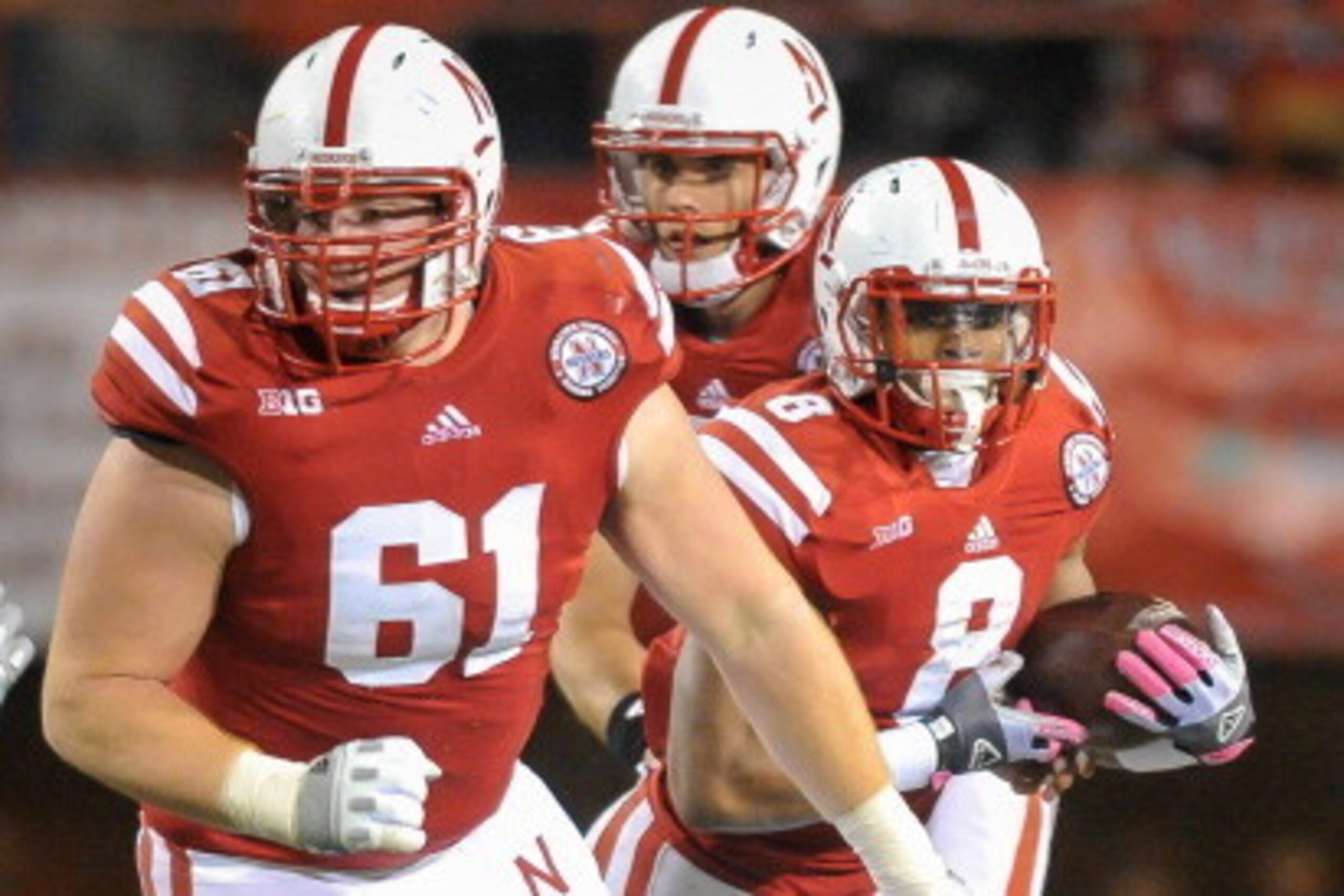 LINCOLN, NE - OCTOBER 27: Offensive linesman Spencer Long #61 of the Nebraska Cornhuskers leads teammates running back Ameer Abdullah #8 and quarterback Taylor Martinez #3 downfield against the Michigan Wolverines during their game at Memorial Stadium on 