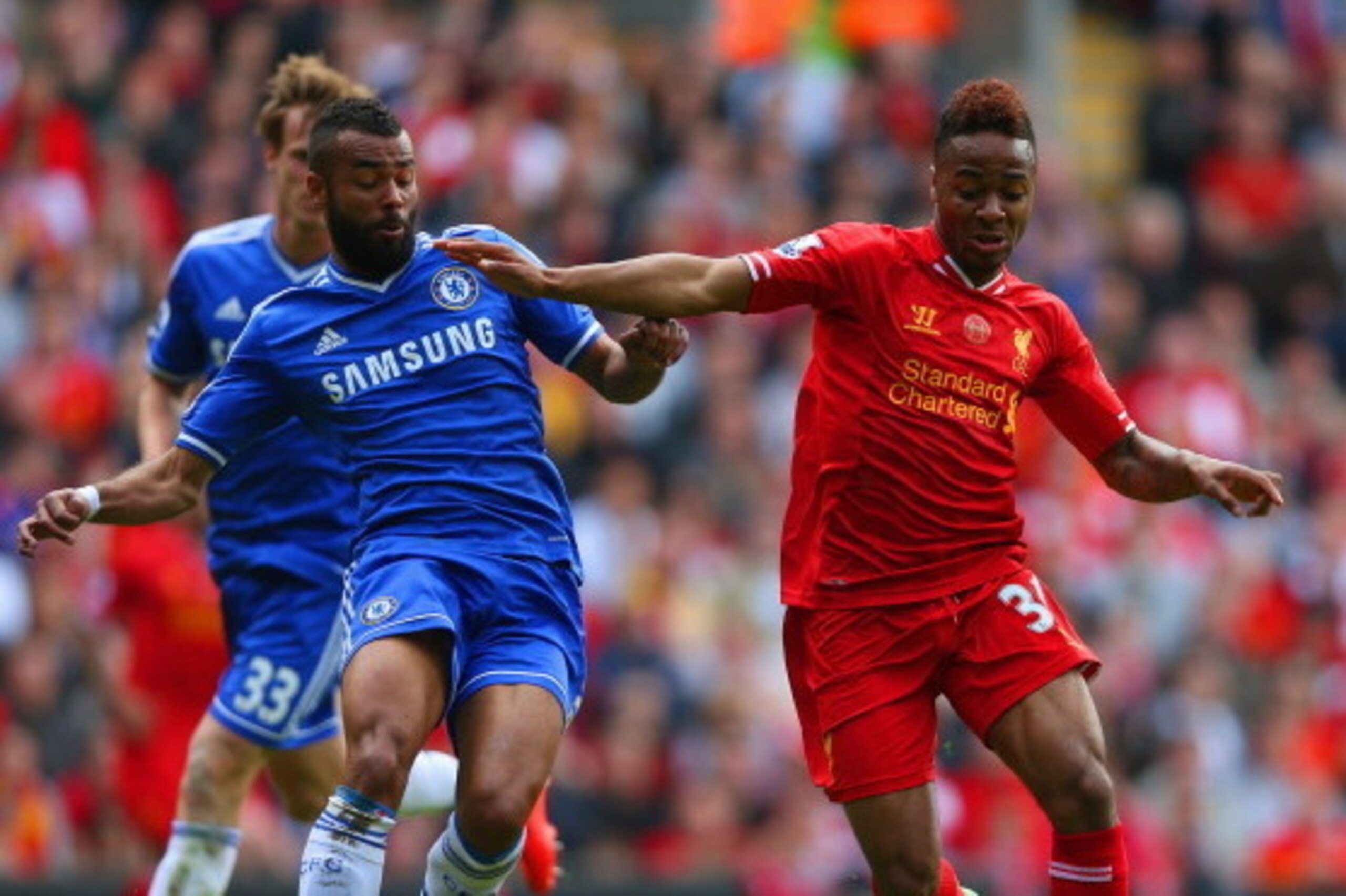 LIVERPOOL, ENGLAND - APRIL 27: Ashley Cole of Chelsea and Raheem Sterling of Liverpool battle for the ball during the Barclays Premier League match between Liverpool and Chelsea at Anfield on April 27, 2014 in Liverpool, England.  (Photo by Clive Brunskil