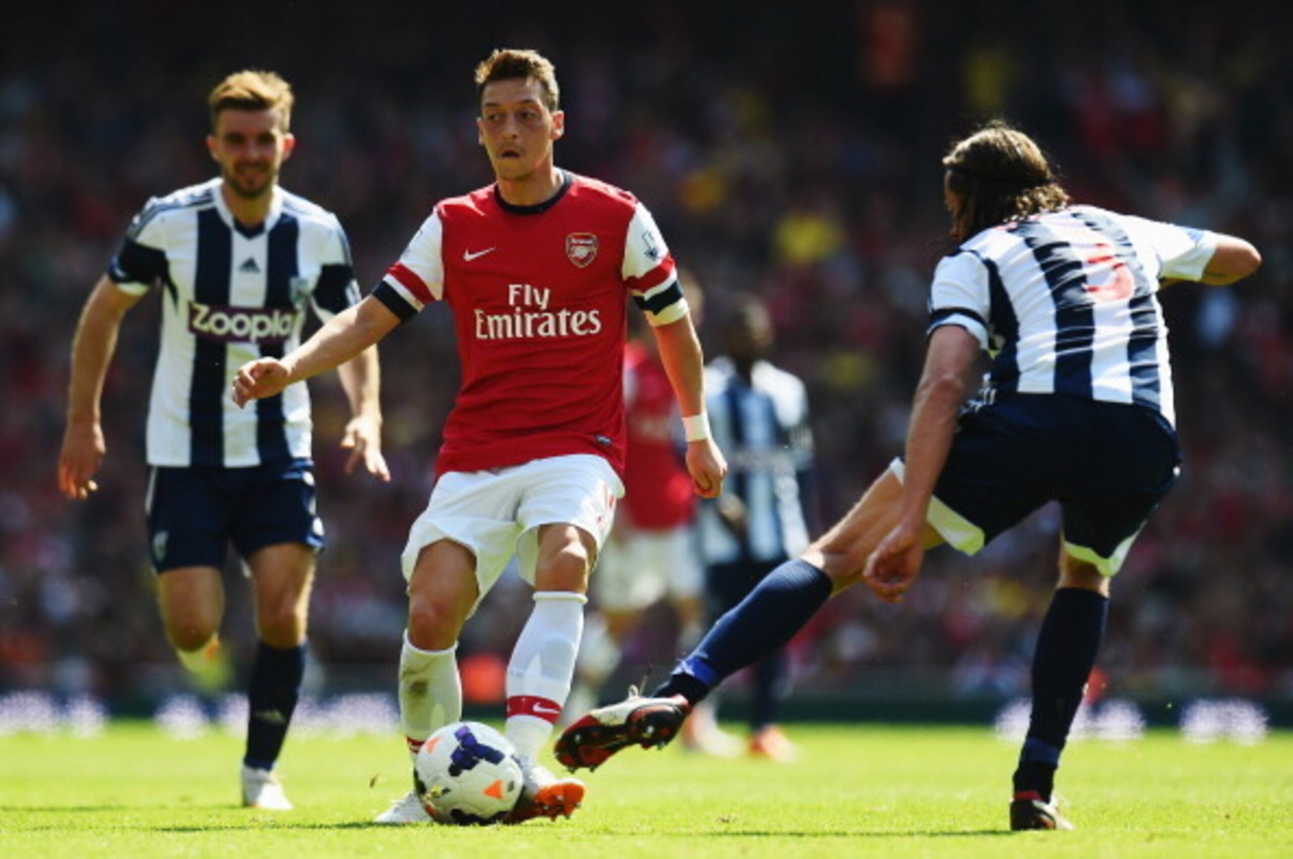 LONDON, ENGLAND - MAY 04:  Mesut Ozil of Arsenal is tackled by Jonas Olsson of West Bromwich Albion during the Barclays Premier League match between Arsenal and West Bromwich Albion at the Emirates Stadium on May 4, 2014 in London, England.  (Photo by Sha
