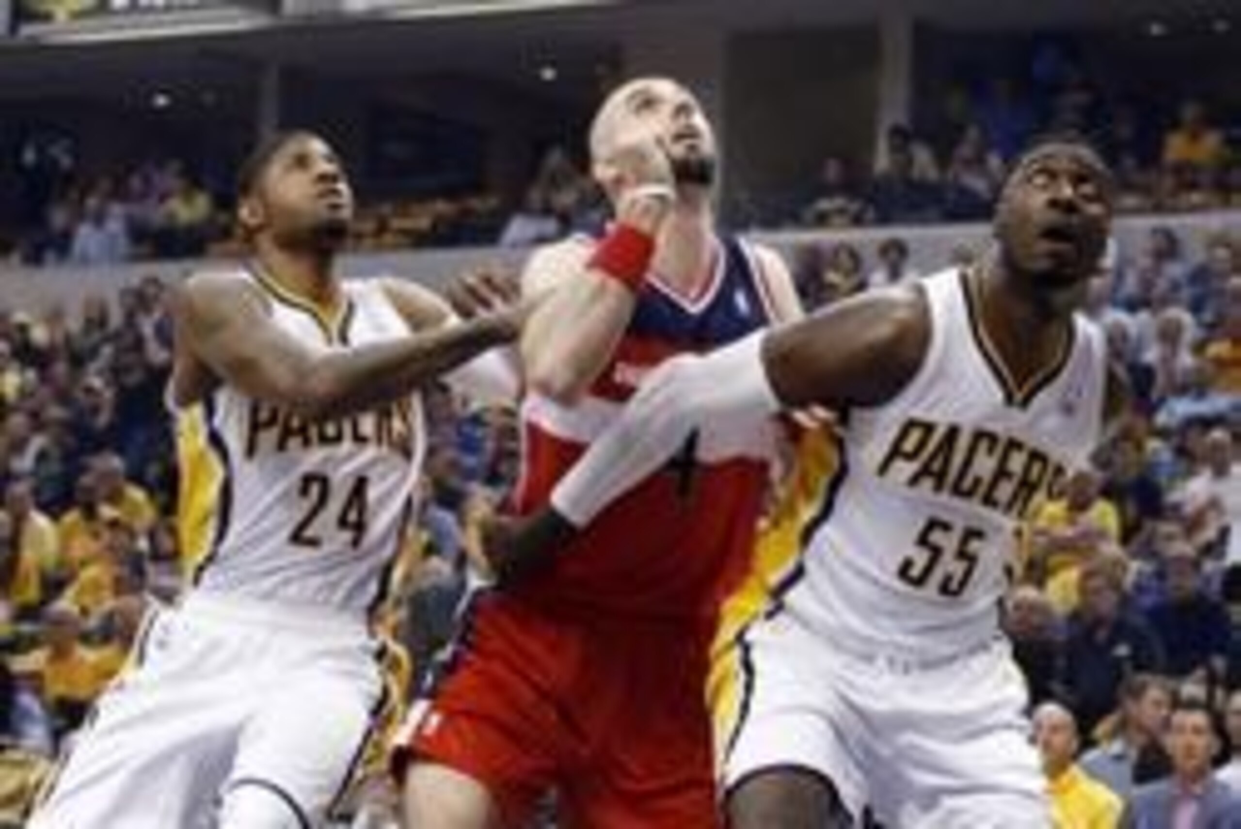 May 7, 2014; Indianapolis, IN, USA; Washington Wizards center Marcin Gortat (4) battles for rebounding position with Indiana Pacers center Roy Hibbert (55) and forward Paul George (24) in game two of the second round of the 2014 NBA Playoffs at Bankers Li