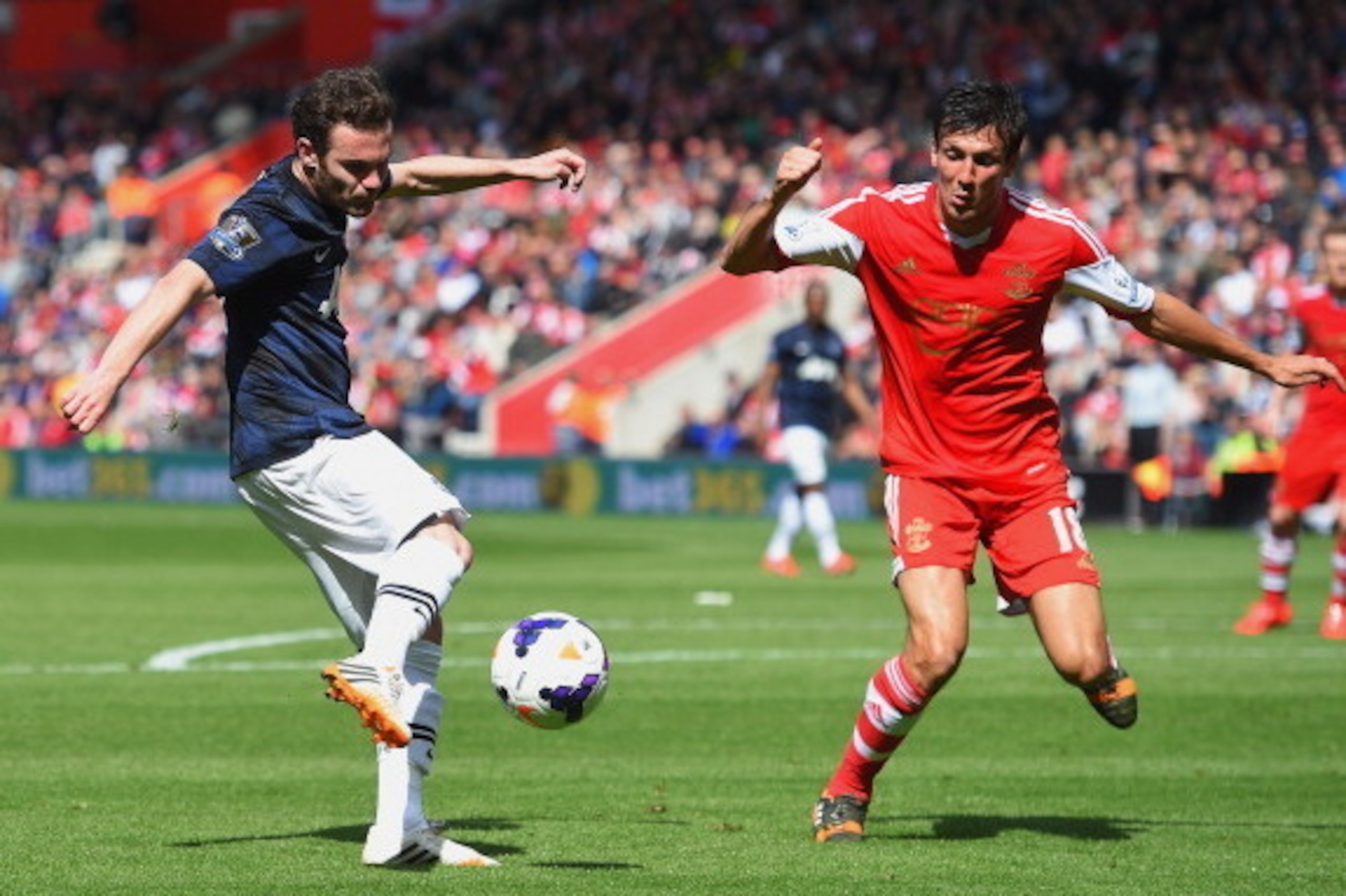 SOUTHAMPTON, ENGLAND - MAY 11:  (L-R) Juan Mata of Manchester United and Jack Cork of Southampton challenge for the ball during the Barclays Premier League match between Southampton and Manchester United at St Mary's Stadium on May 11, 2014 in Southampton